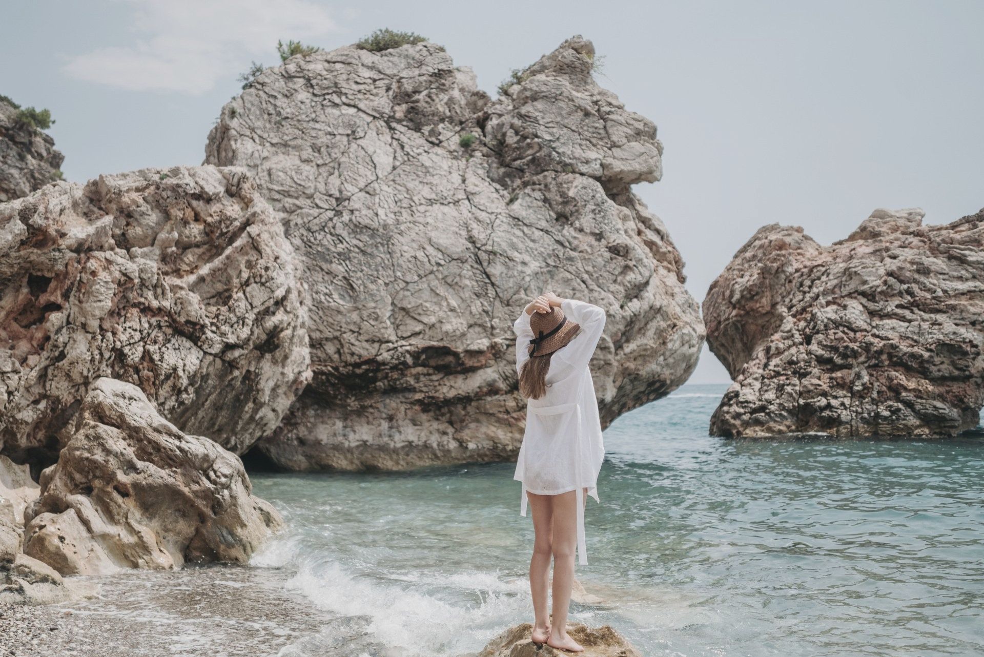 Woman Standing on a Rock in the Beach Woman Standing on a Rock in the Beach