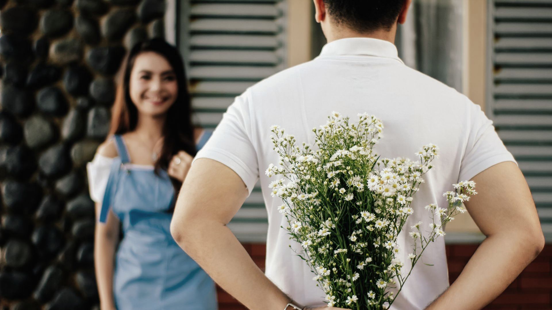 Man Holding Flower in Front of Woman Man Holding Flower in Front of Woman