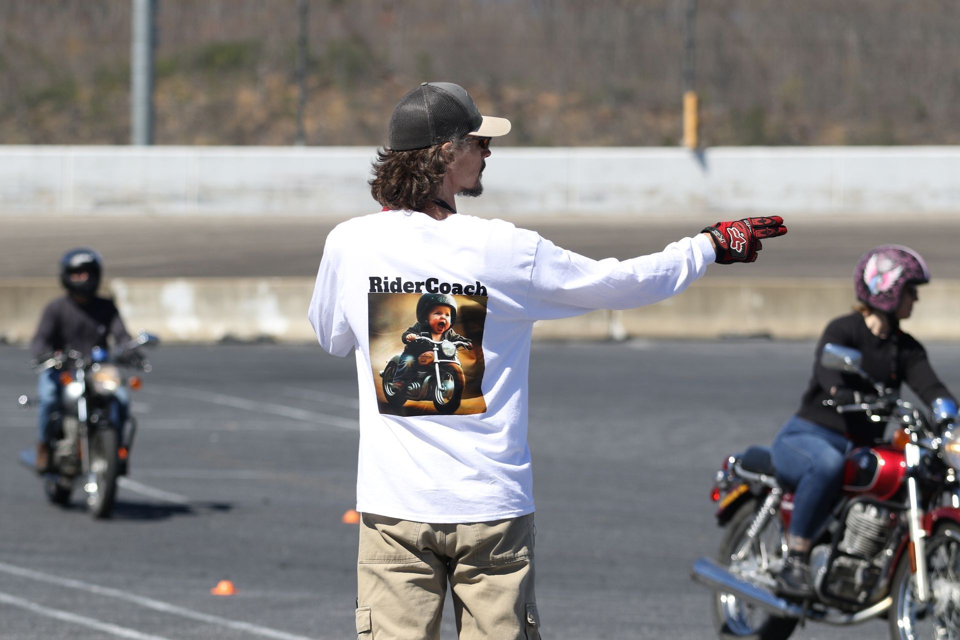 A man wearing a white shirt that says rider coach on it