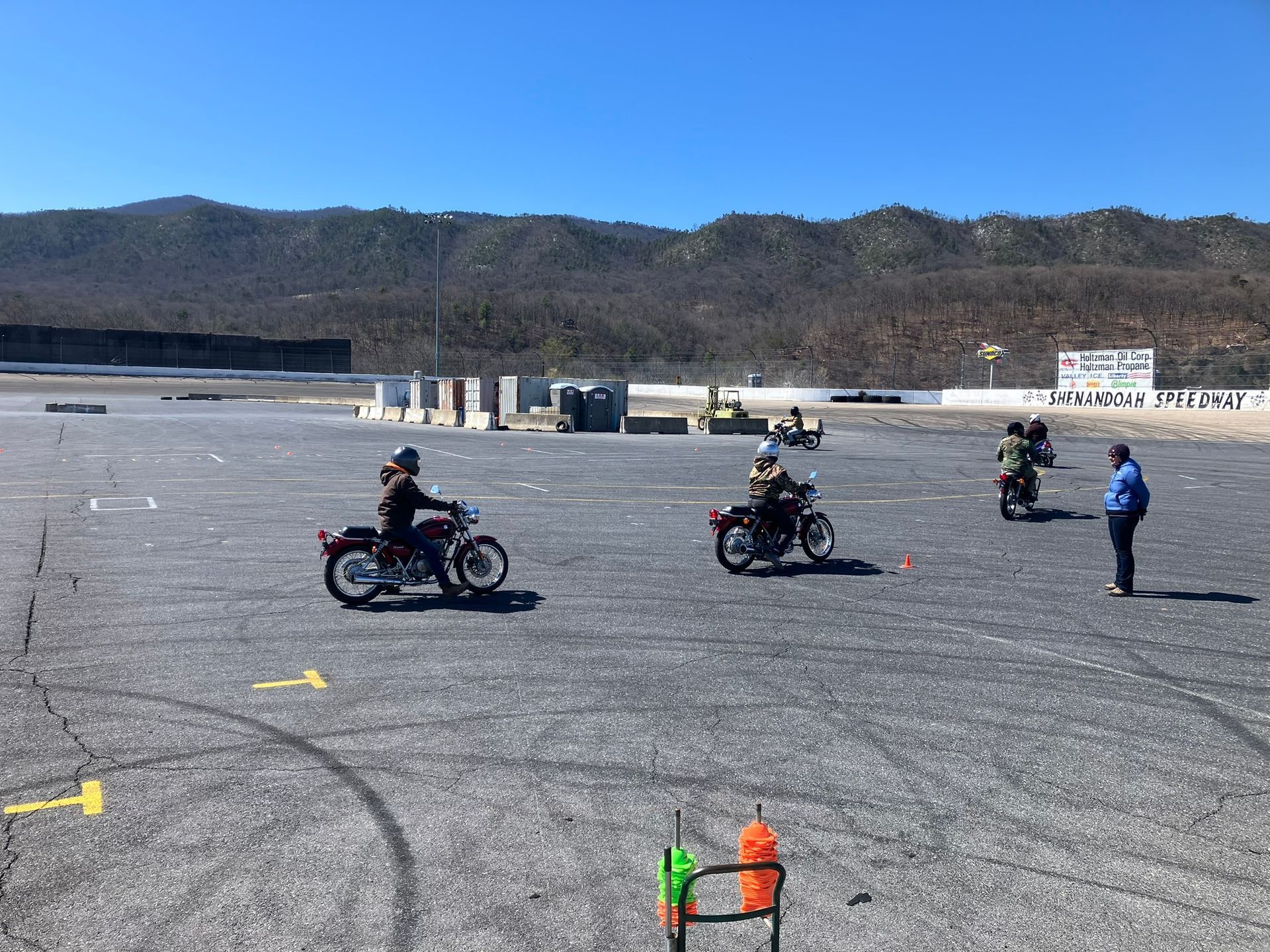 A group of people are riding motorcycles in a parking lot