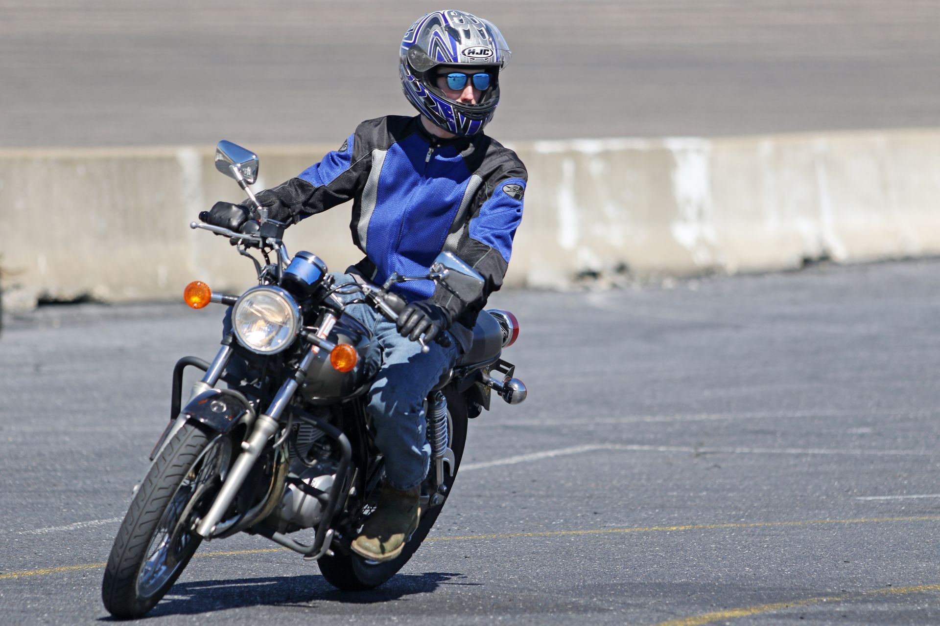 A man wearing a helmet and sunglasses is riding a motorcycle