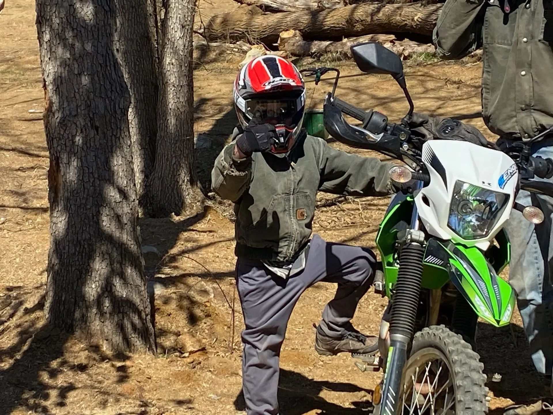 A person wearing a helmet is standing next to a motorcycle