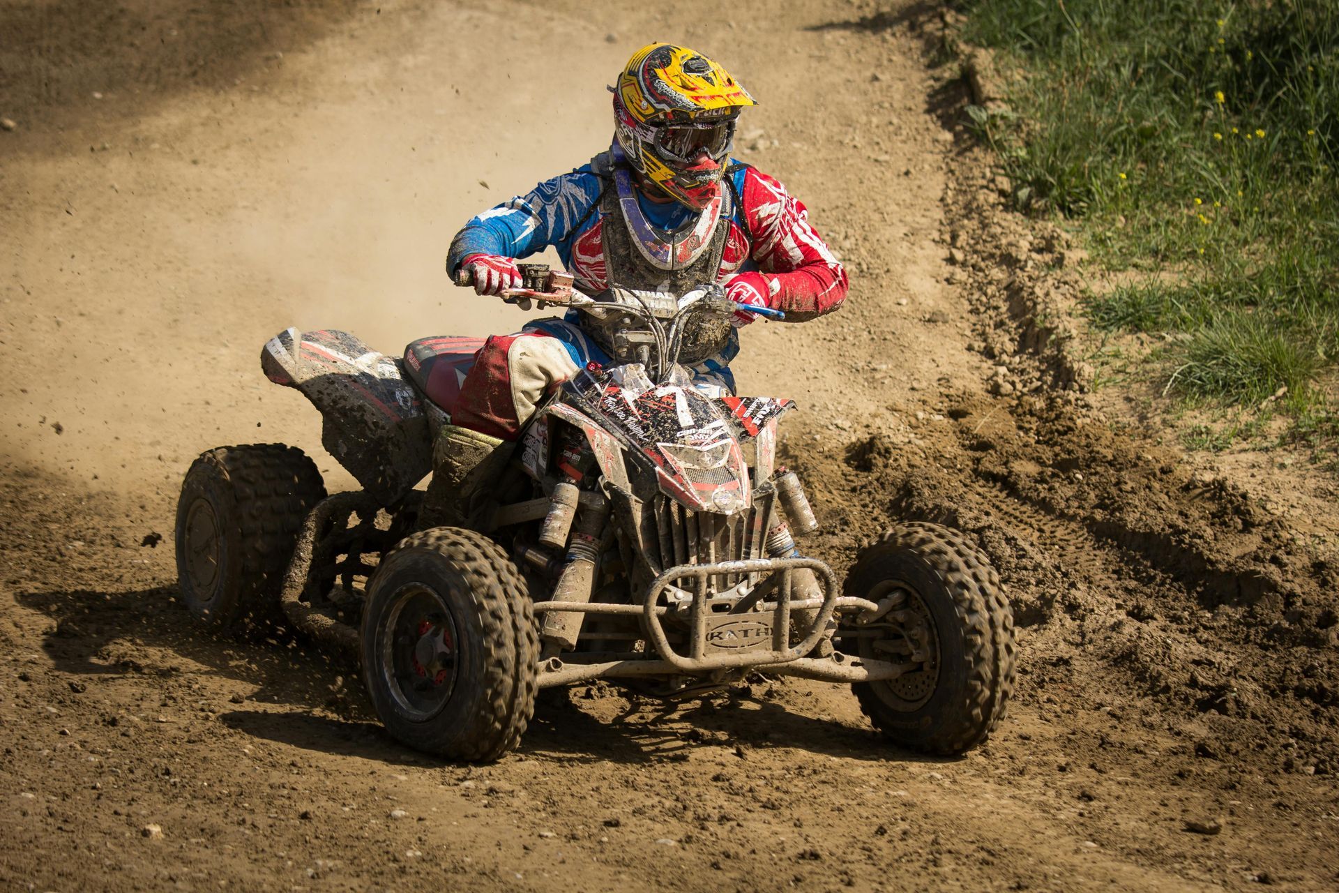 A man is riding a four wheeler on a dirt road