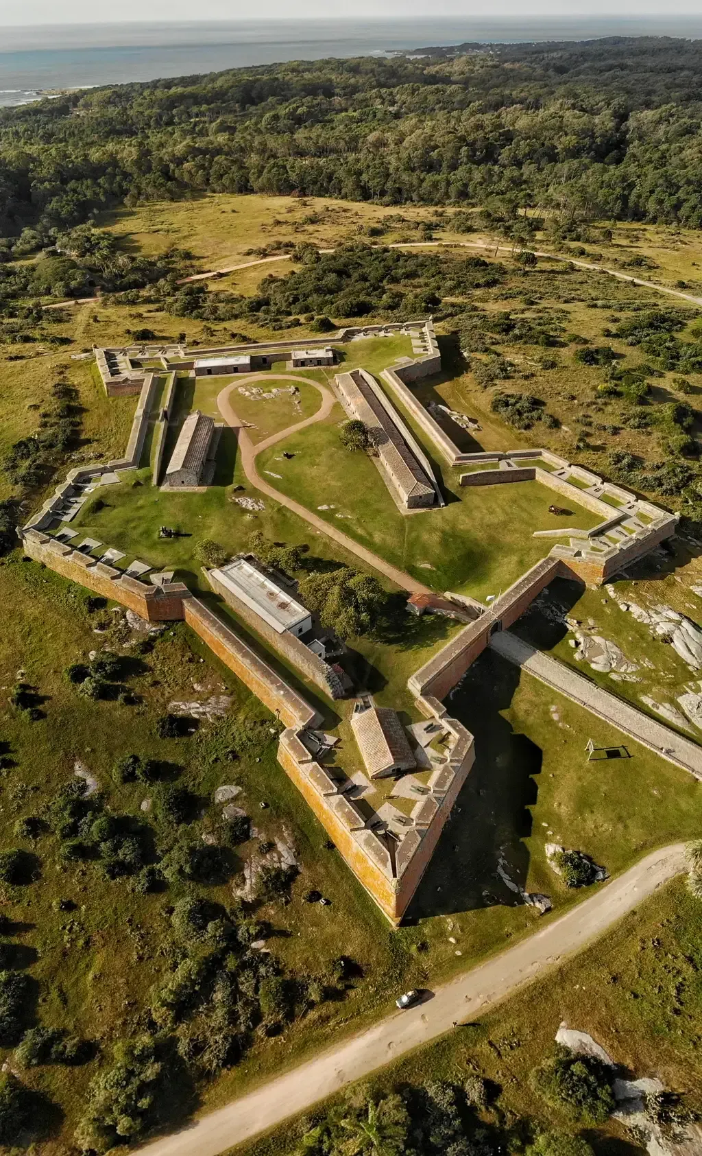 An aerial view of a large building in the middle of a field.