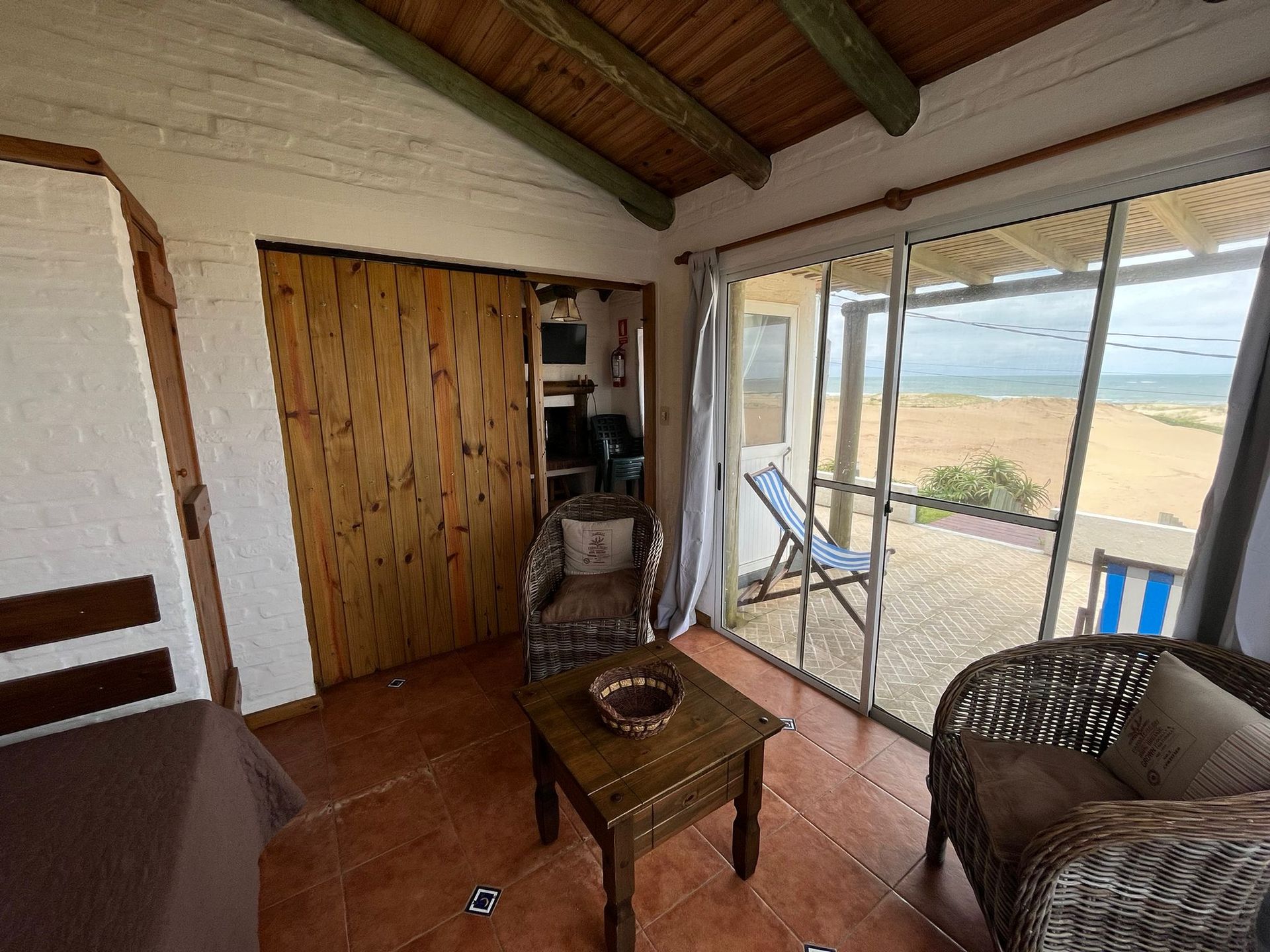 A living room with a table and chairs and a view of the ocean.