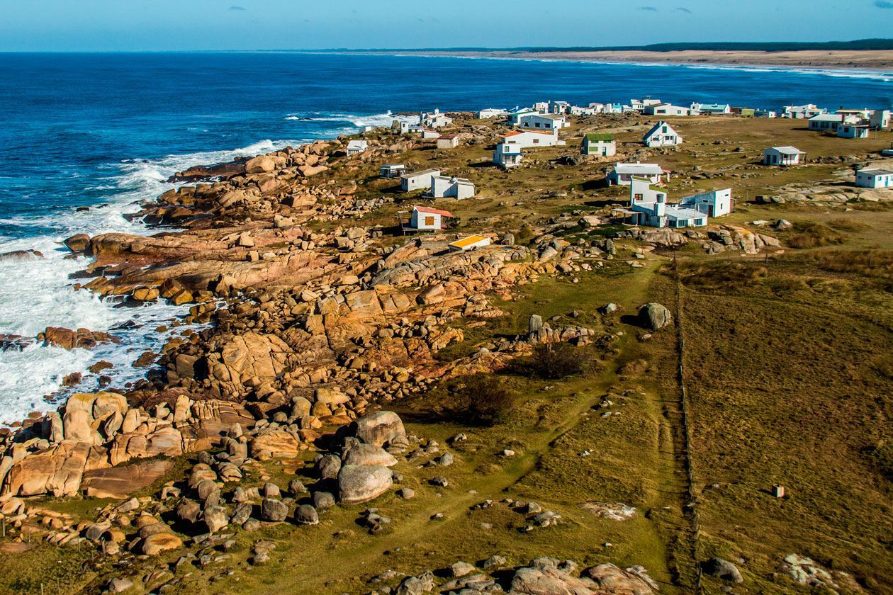 An aerial view of a small village on the shore of the ocean.