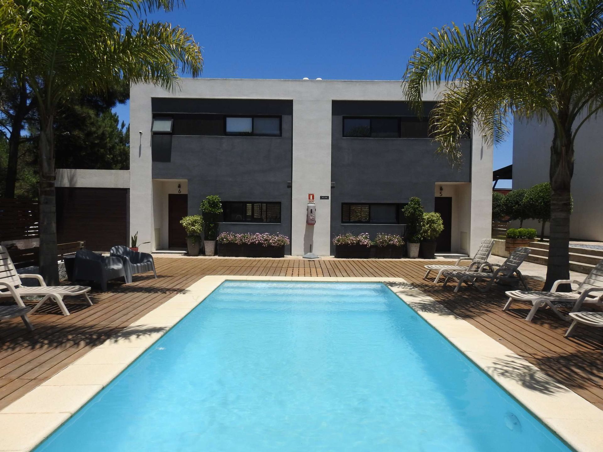 A large swimming pool in front of a house