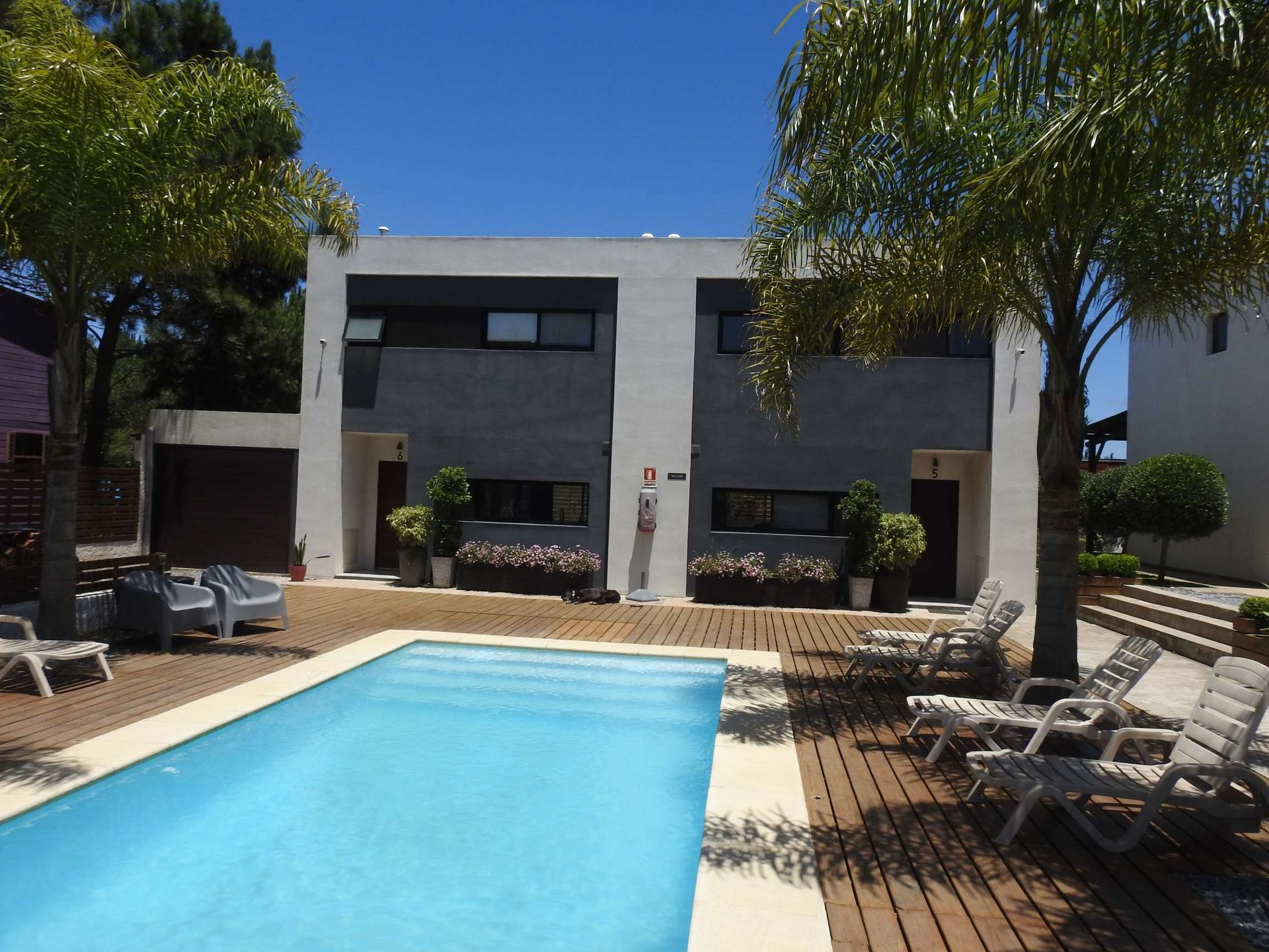 A large swimming pool in front of a house