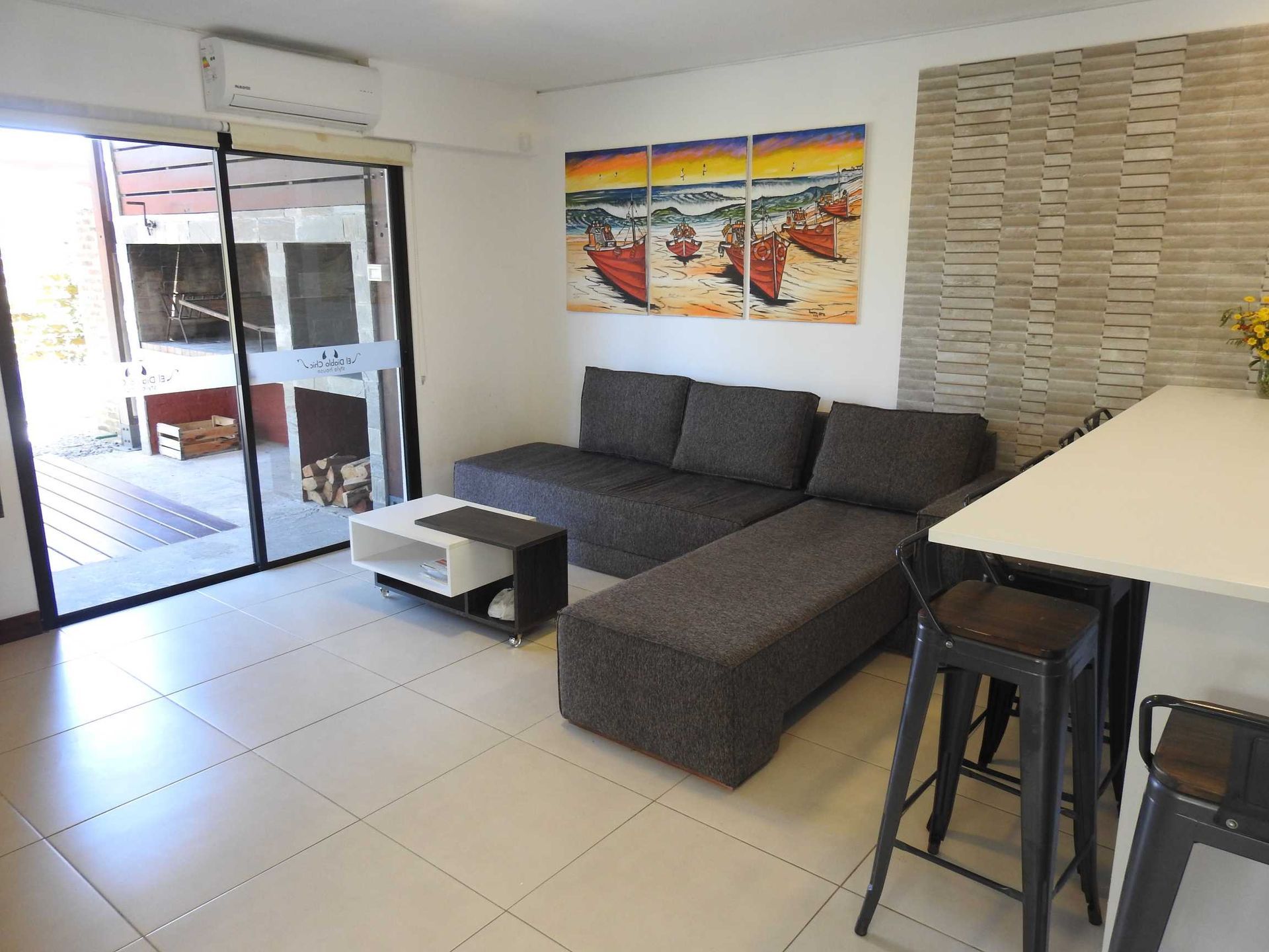 A living room with a couch a table and a painting on the wall