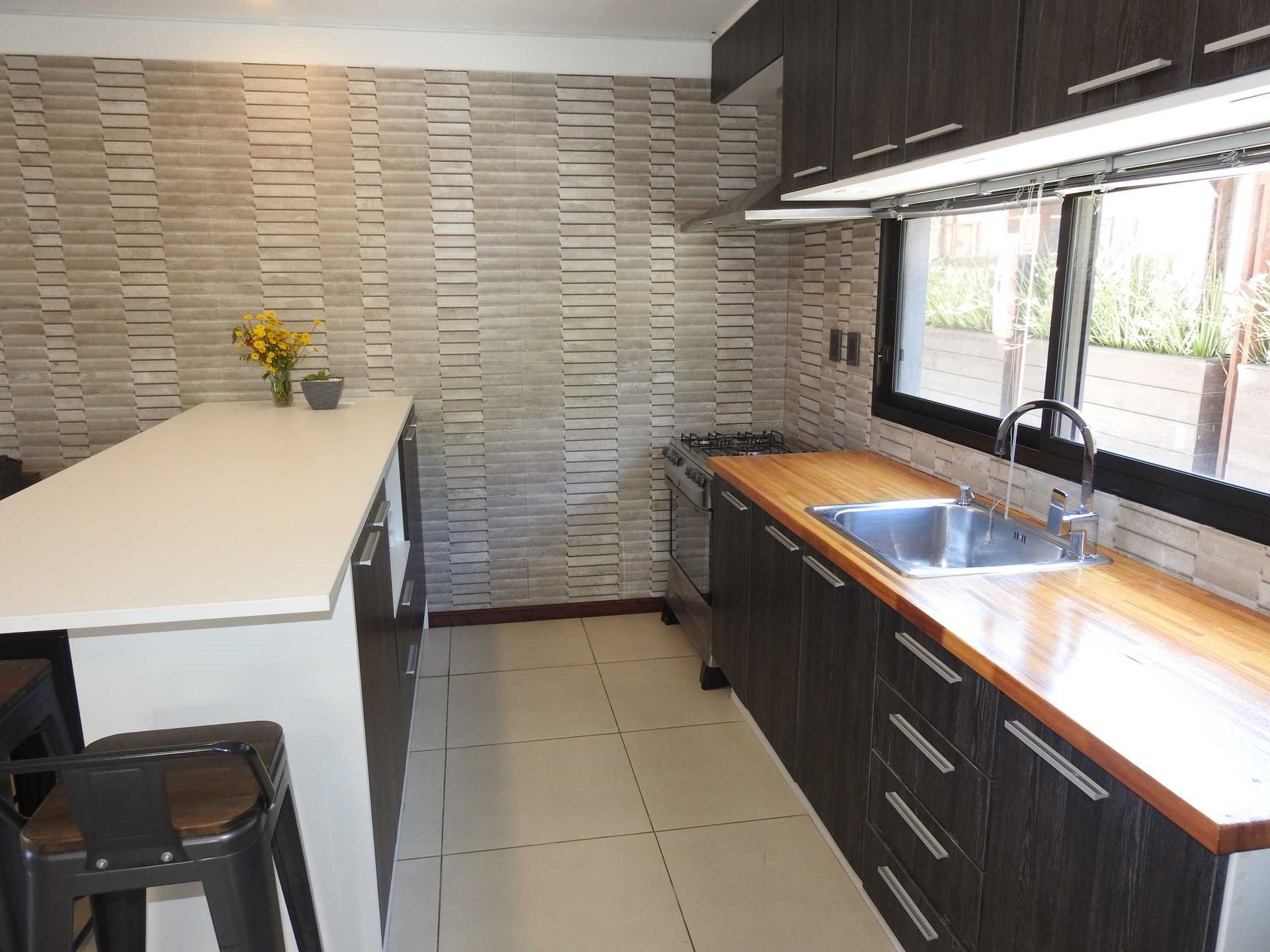 A kitchen with wooden cabinets and a stainless steel sink