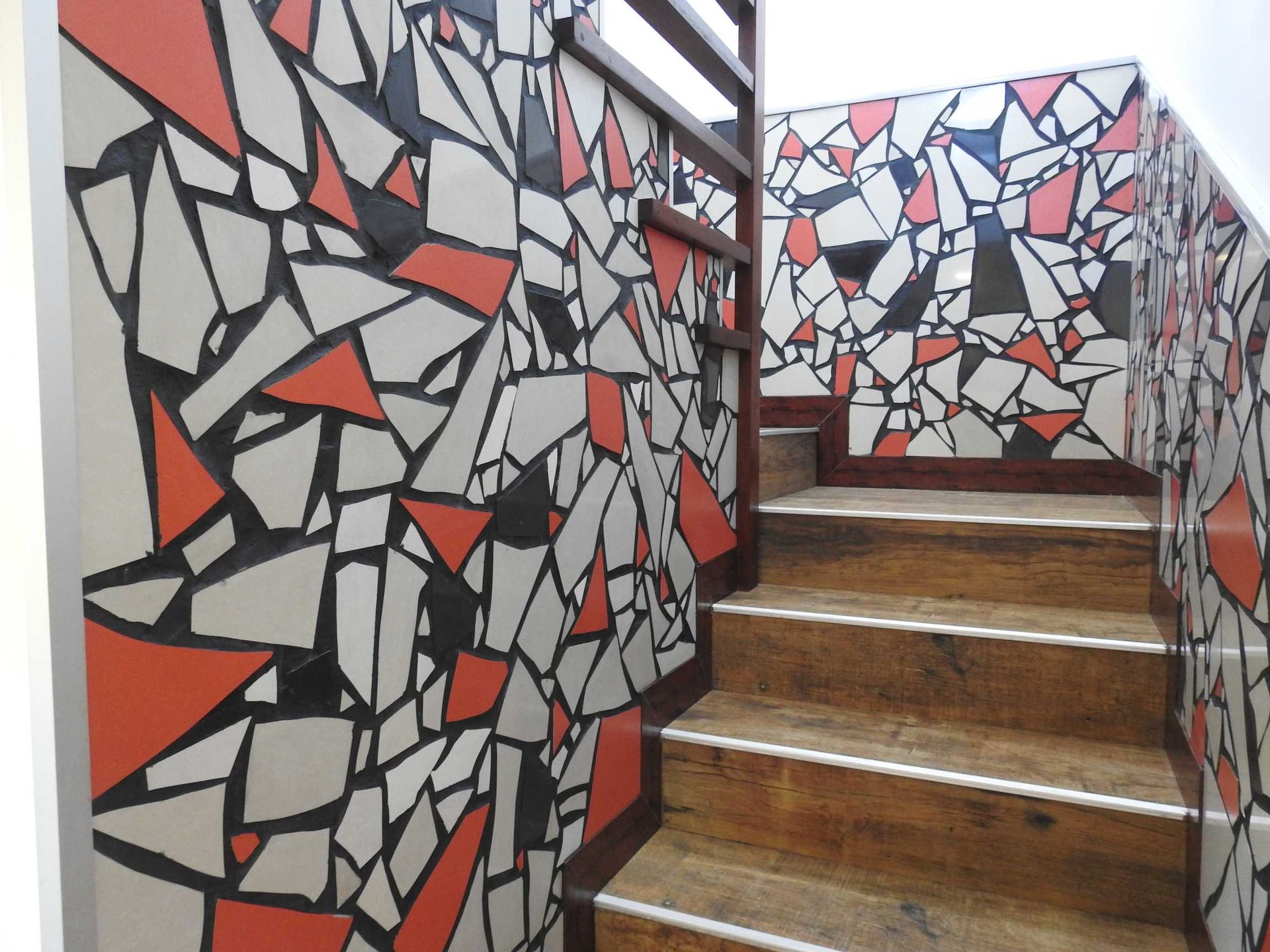 A set of stairs with a mosaic wall behind them