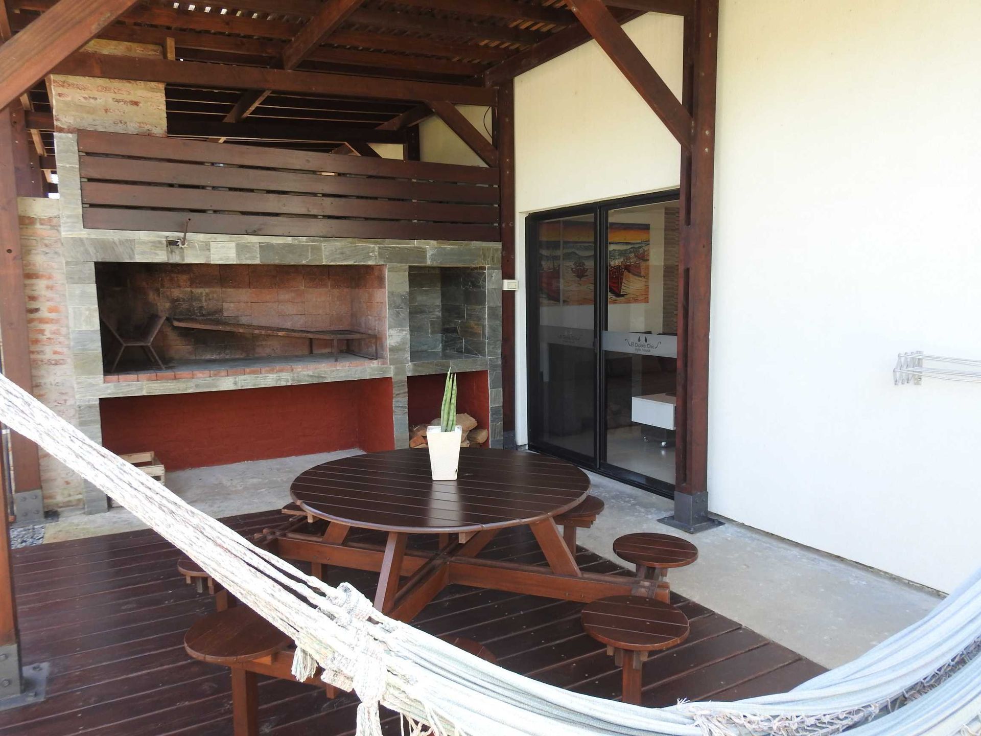 A patio with a table and chairs and a hammock