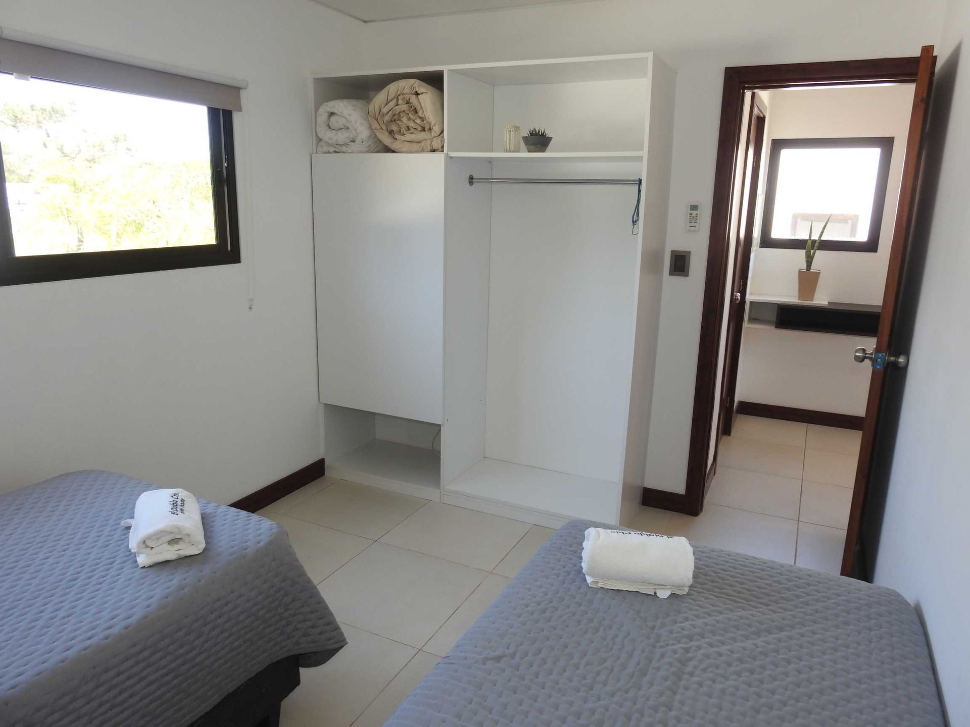 A bedroom with two beds and a closet