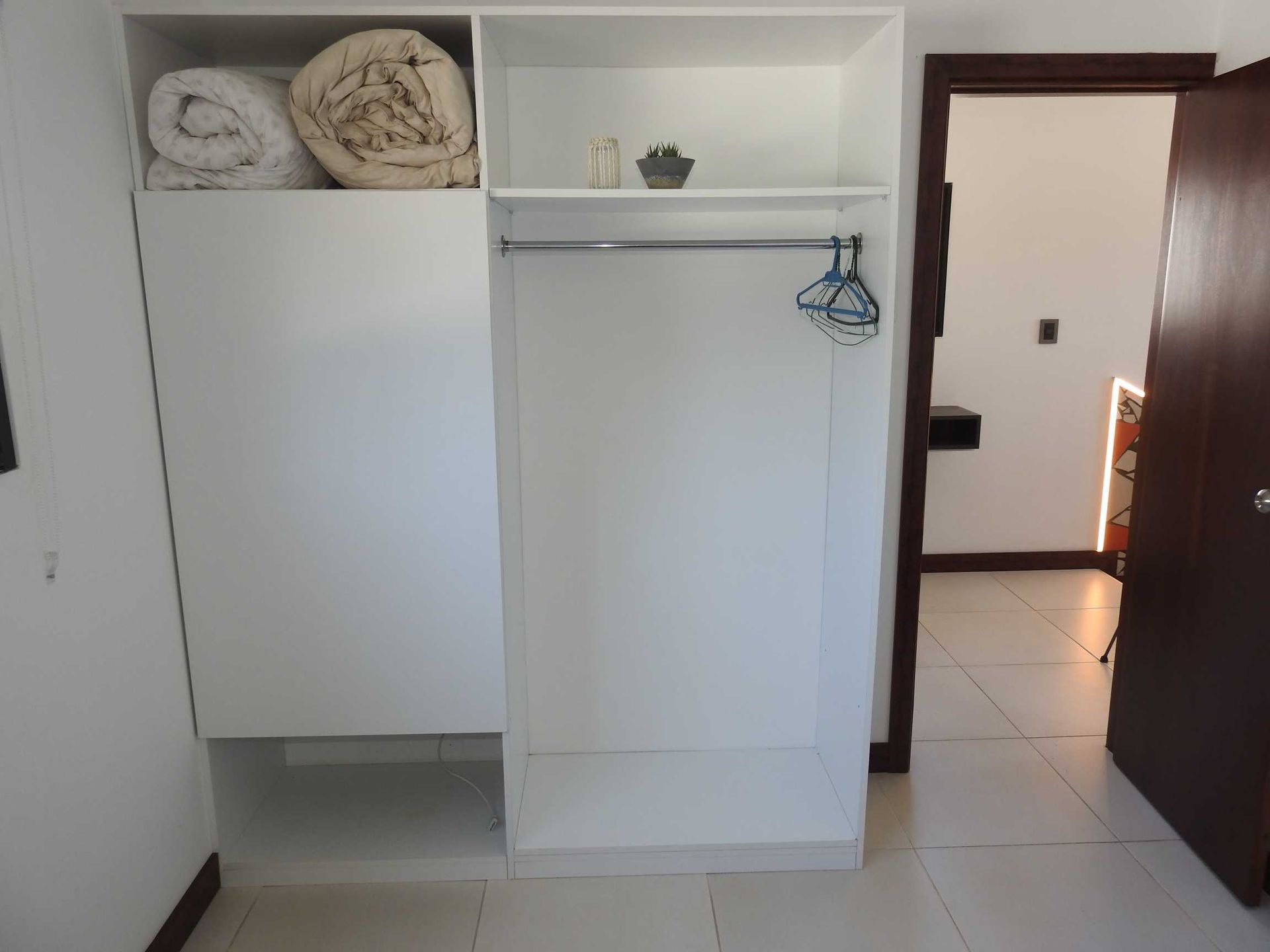 A white closet with a blanket on top of it