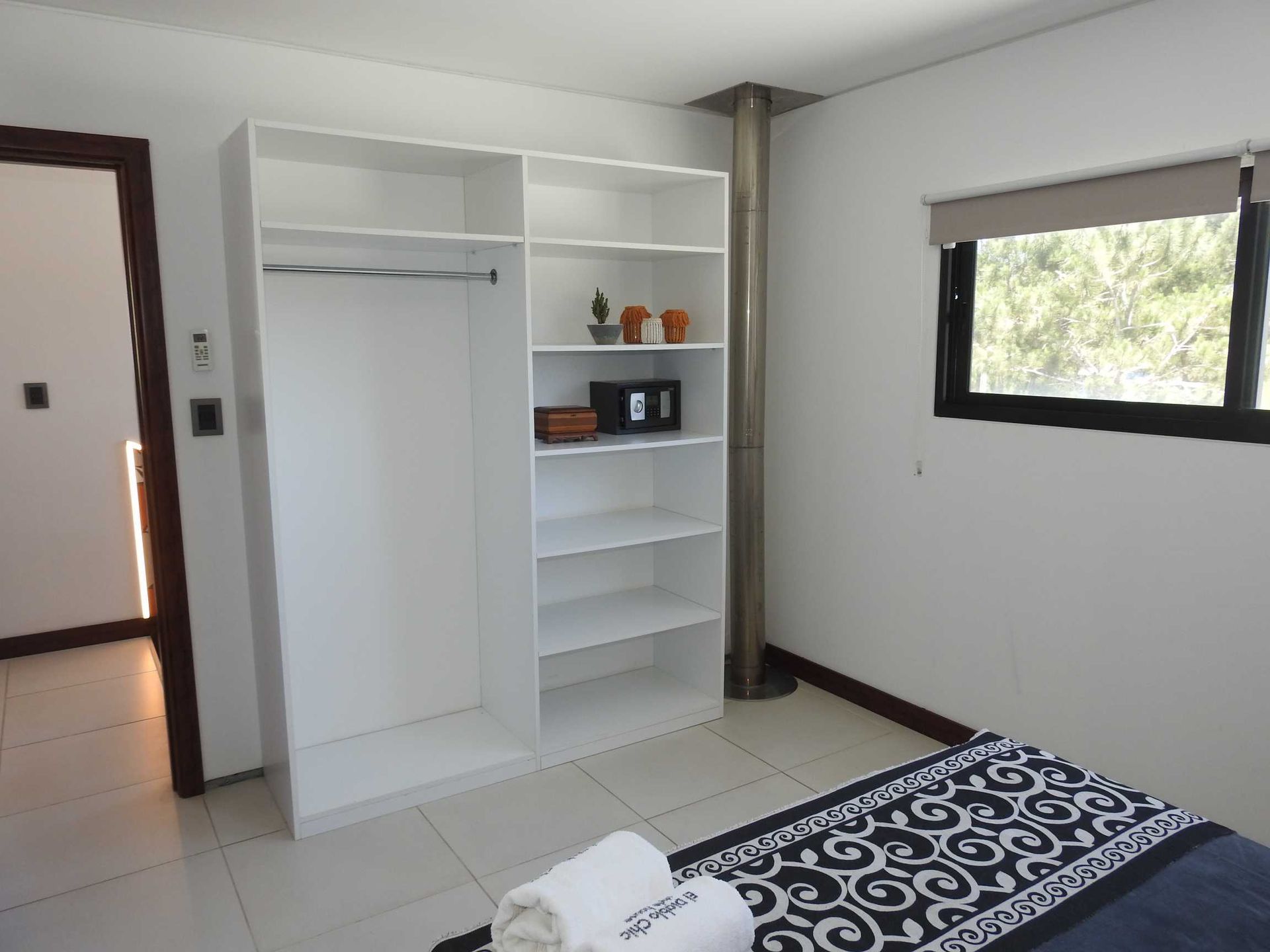 A bedroom with a bed , closet and window
