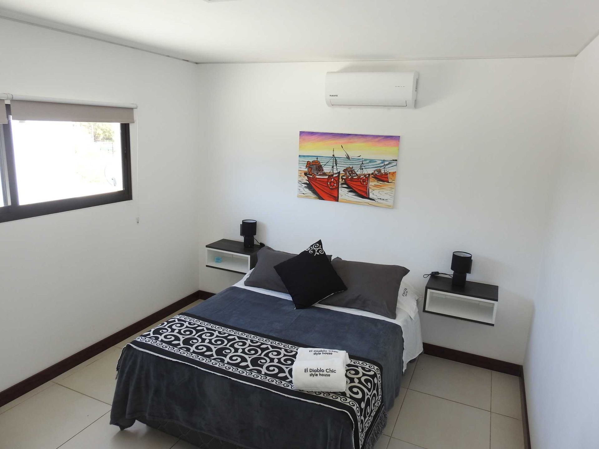 A bedroom with a bed and a painting on the wall