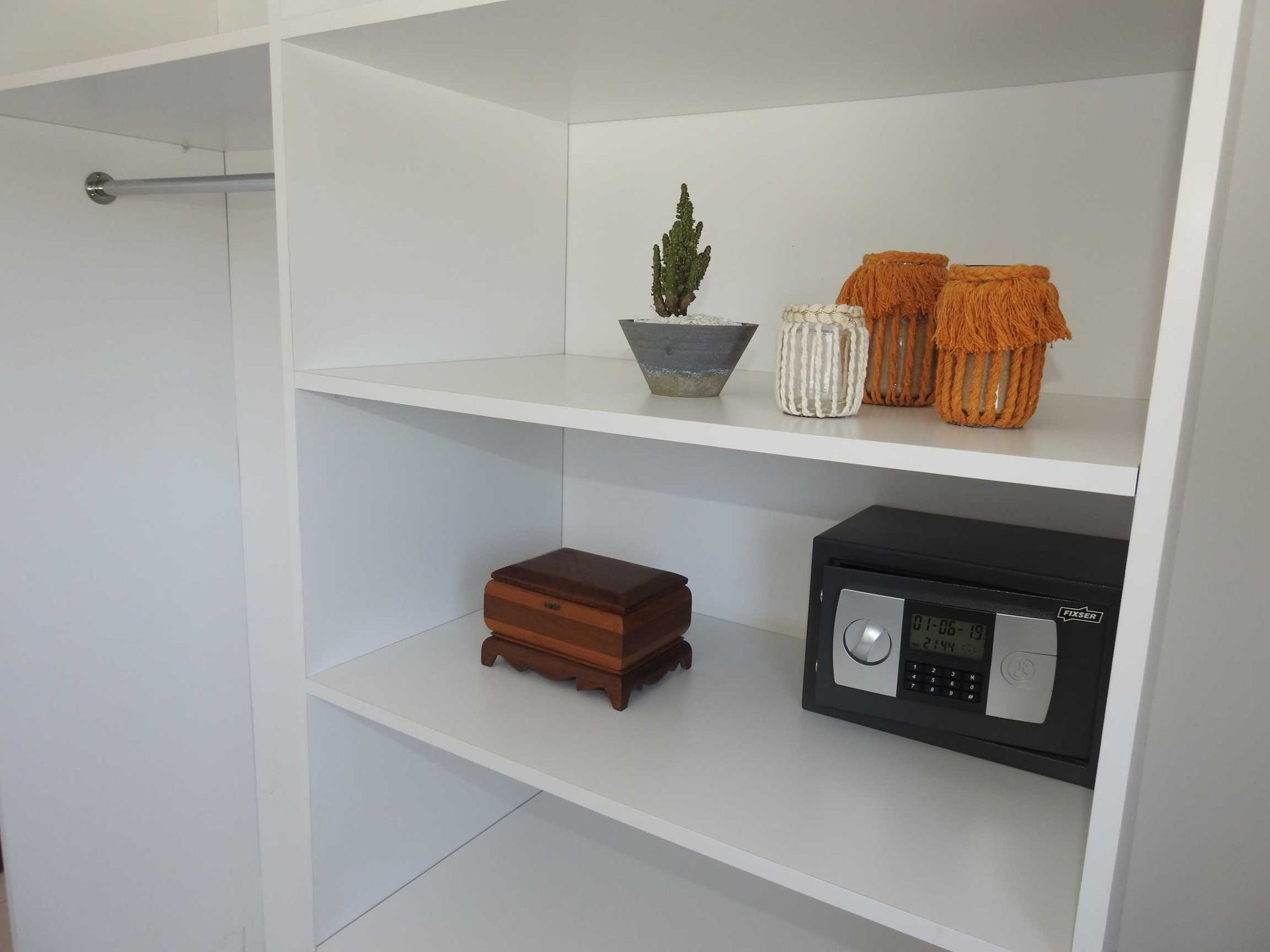 A shelf with a clock and a box on it