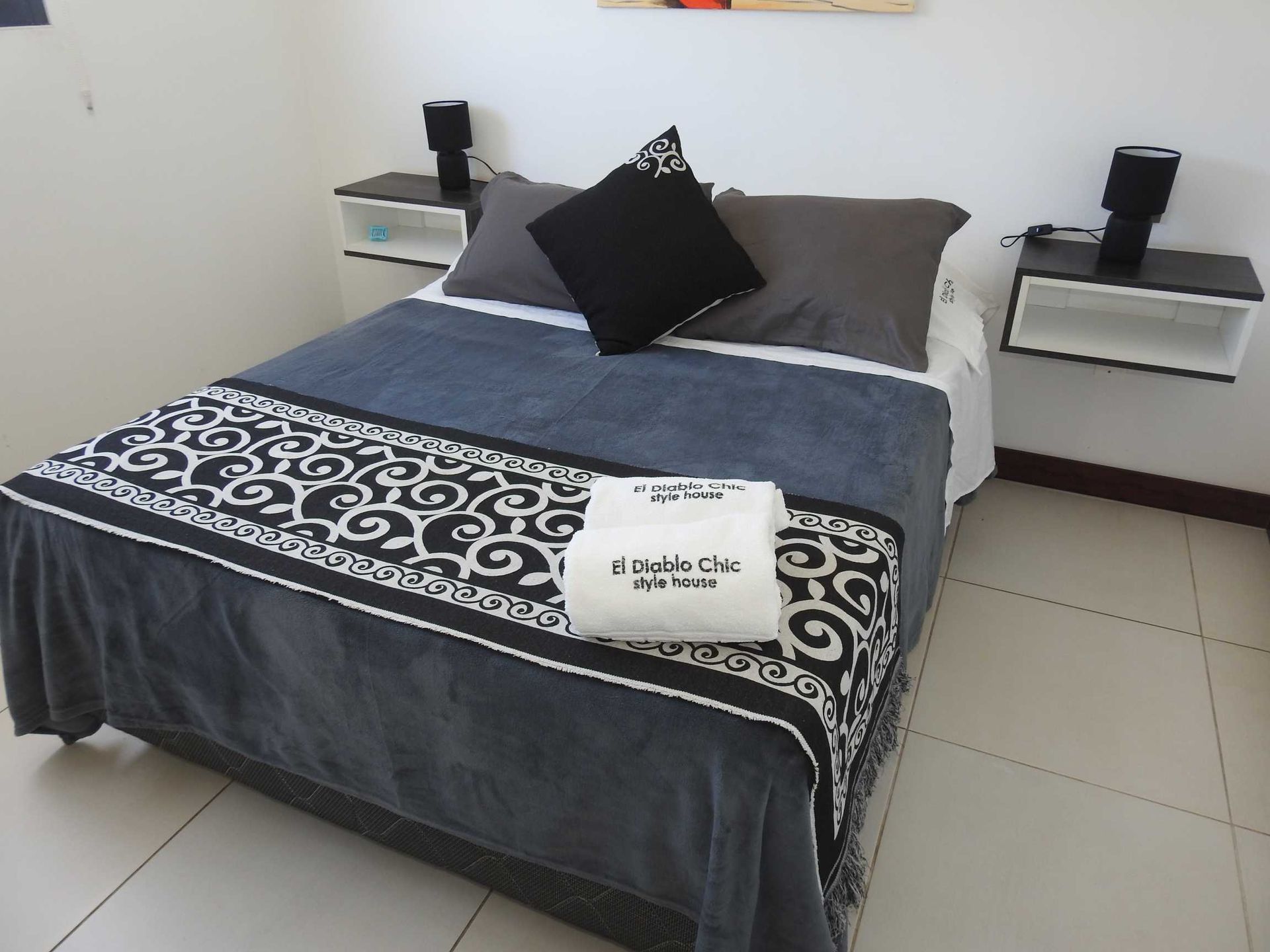 A bed with a black and white blanket and pillows