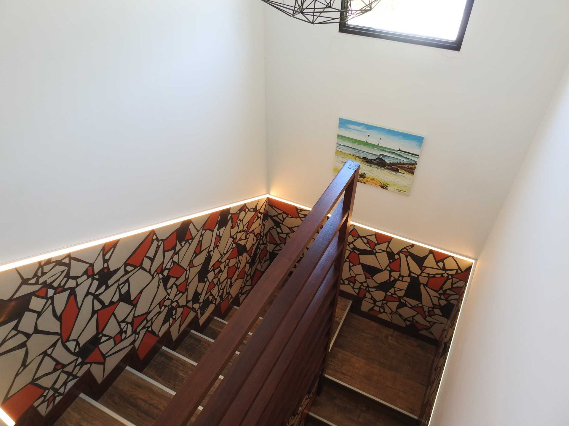 A staircase with a painting on the wall above it