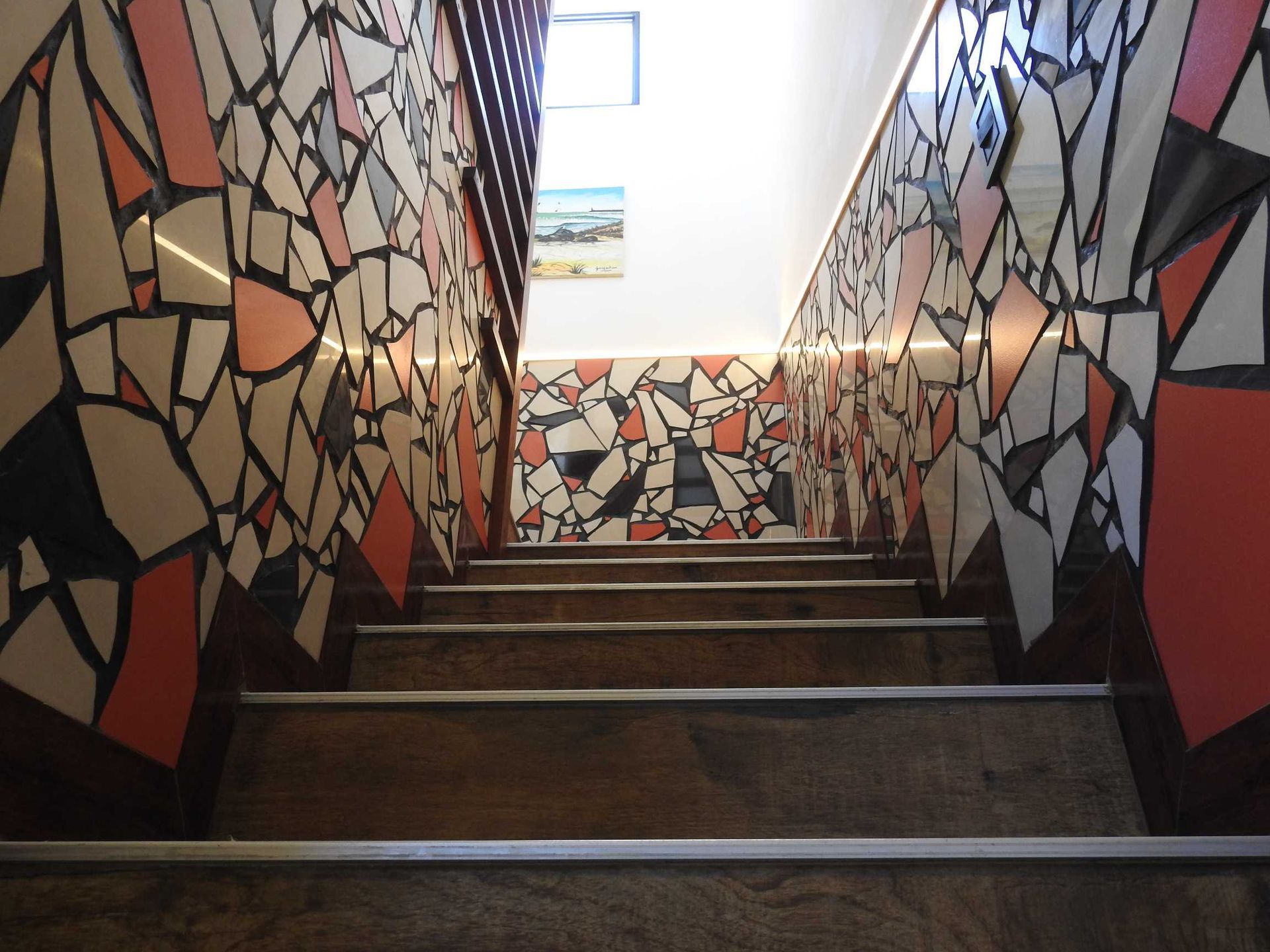 A set of stairs with a mosaic wall behind them