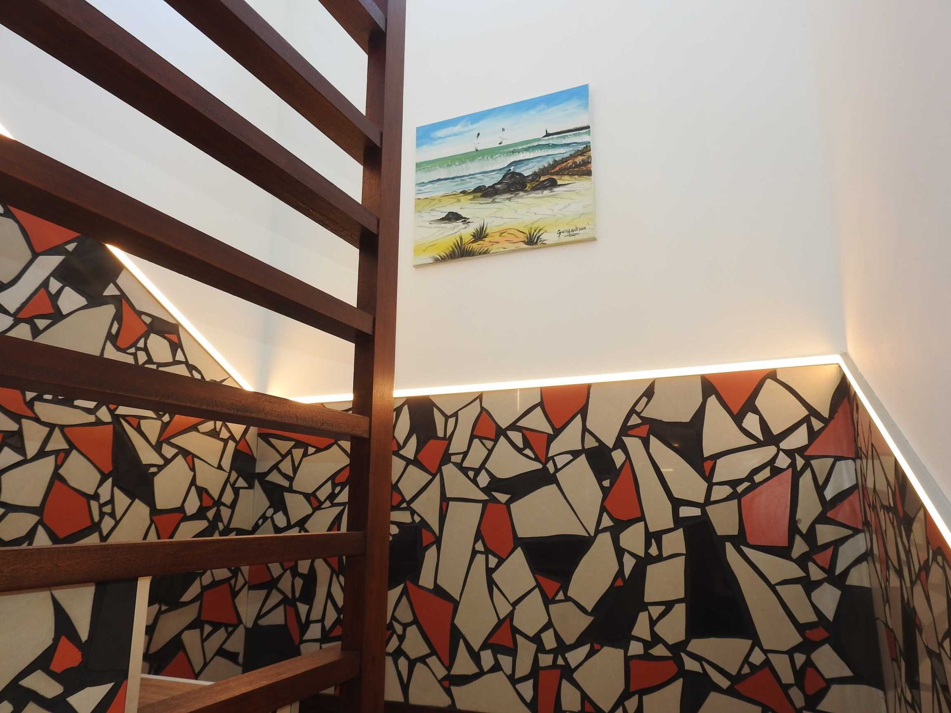 A staircase with a picture on the wall above it