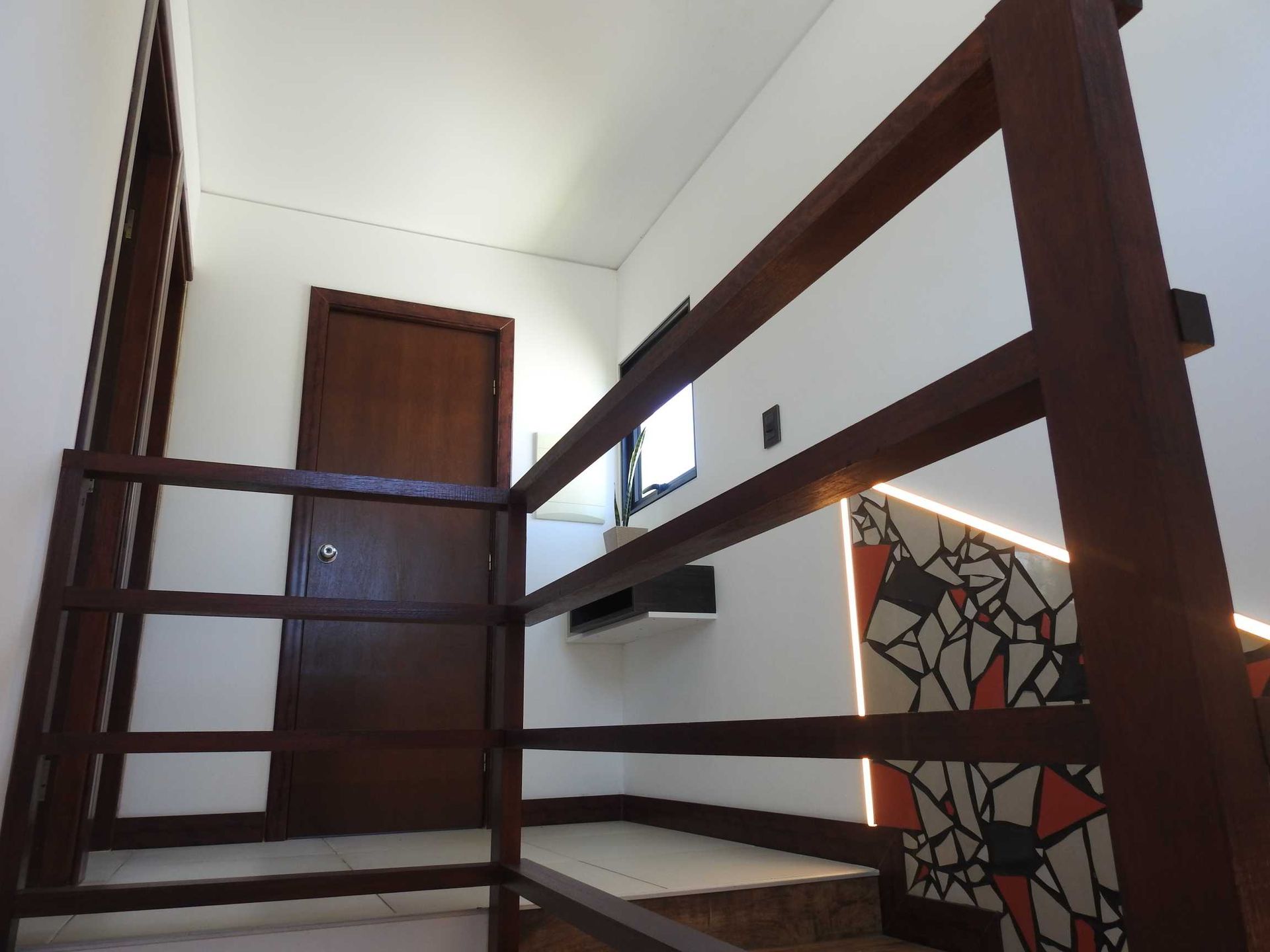 A staircase with a wooden railing and a door