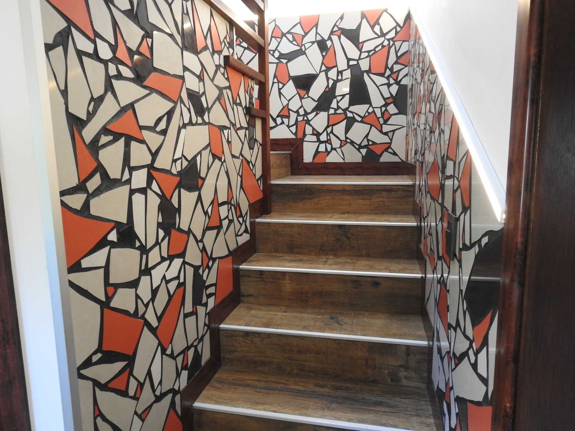 A set of stairs with a mosaic wall behind them