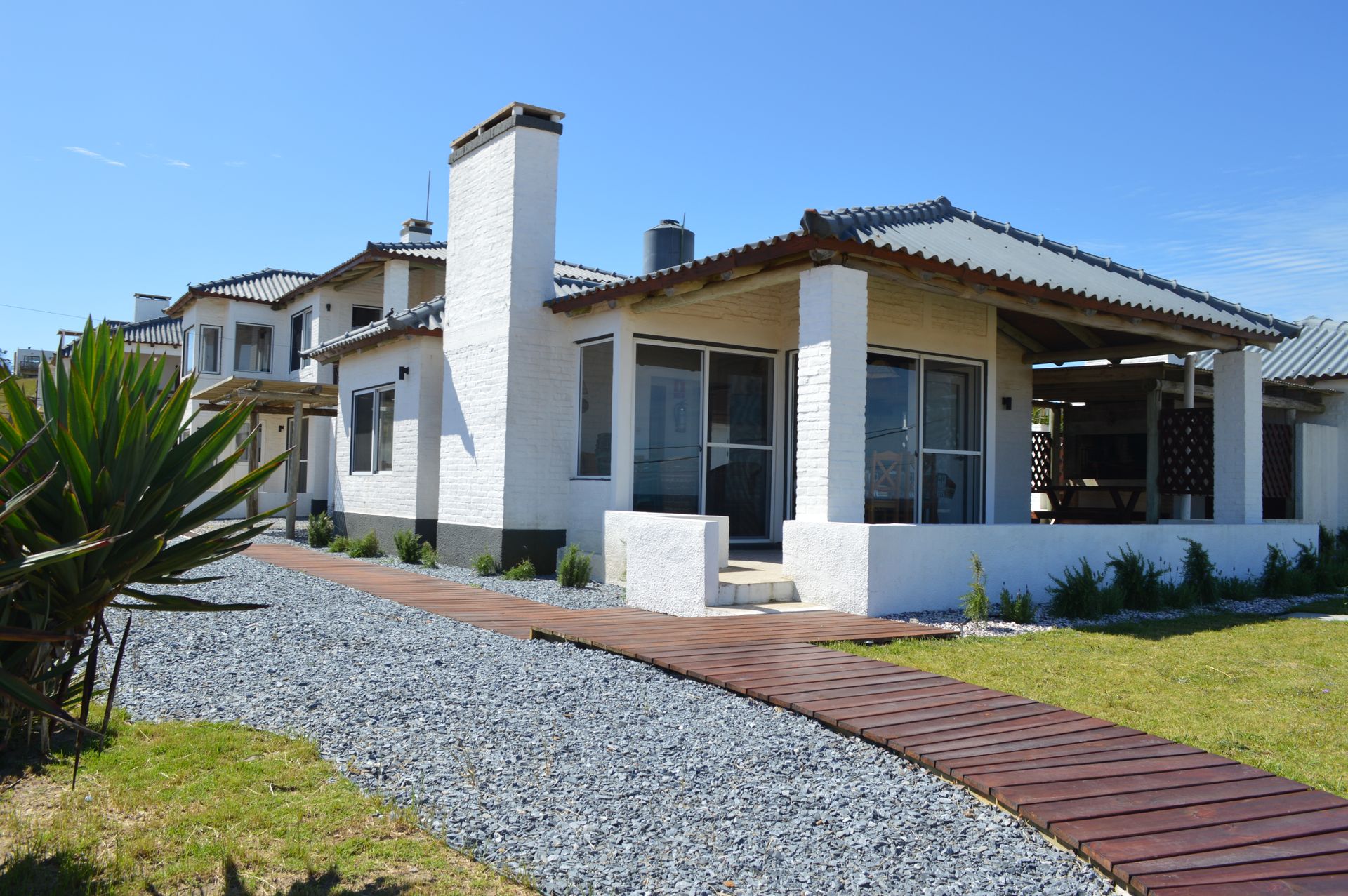A white house with a wooden walkway leading to it