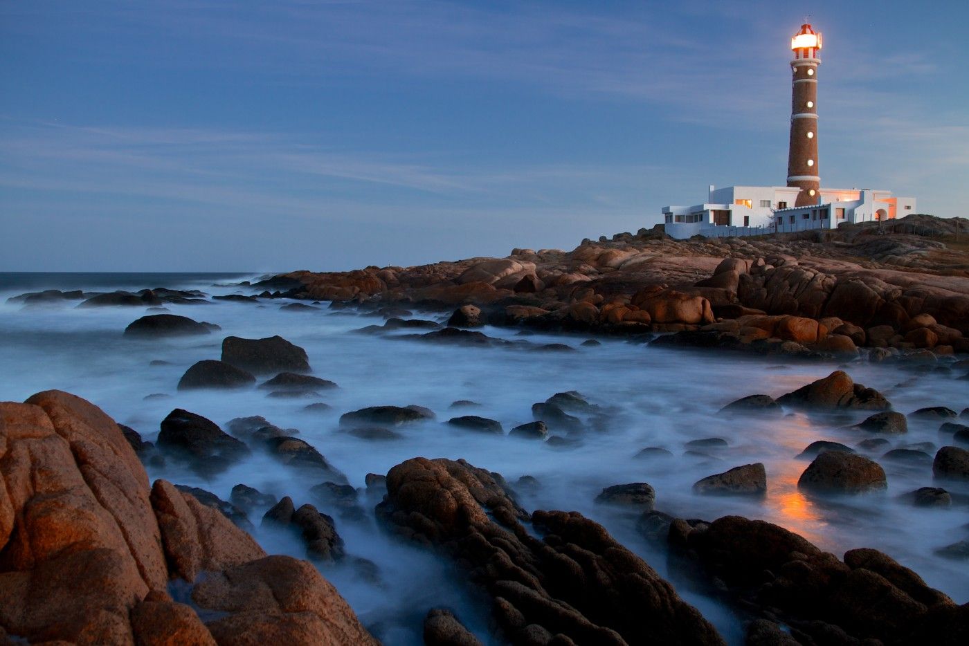 A lighthouse on a rocky cliff overlooking the ocean