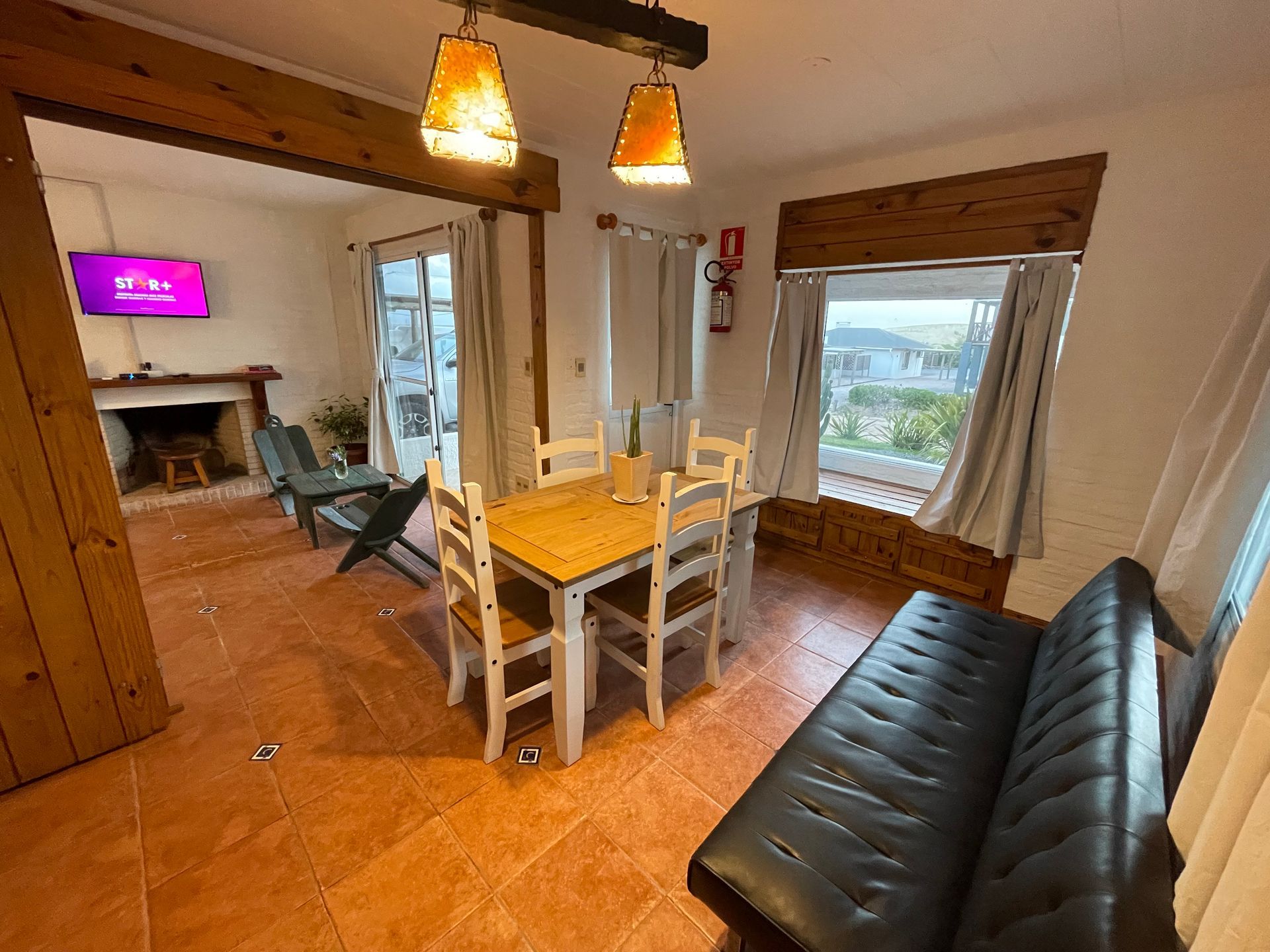 A living room with a table and chairs and a couch.