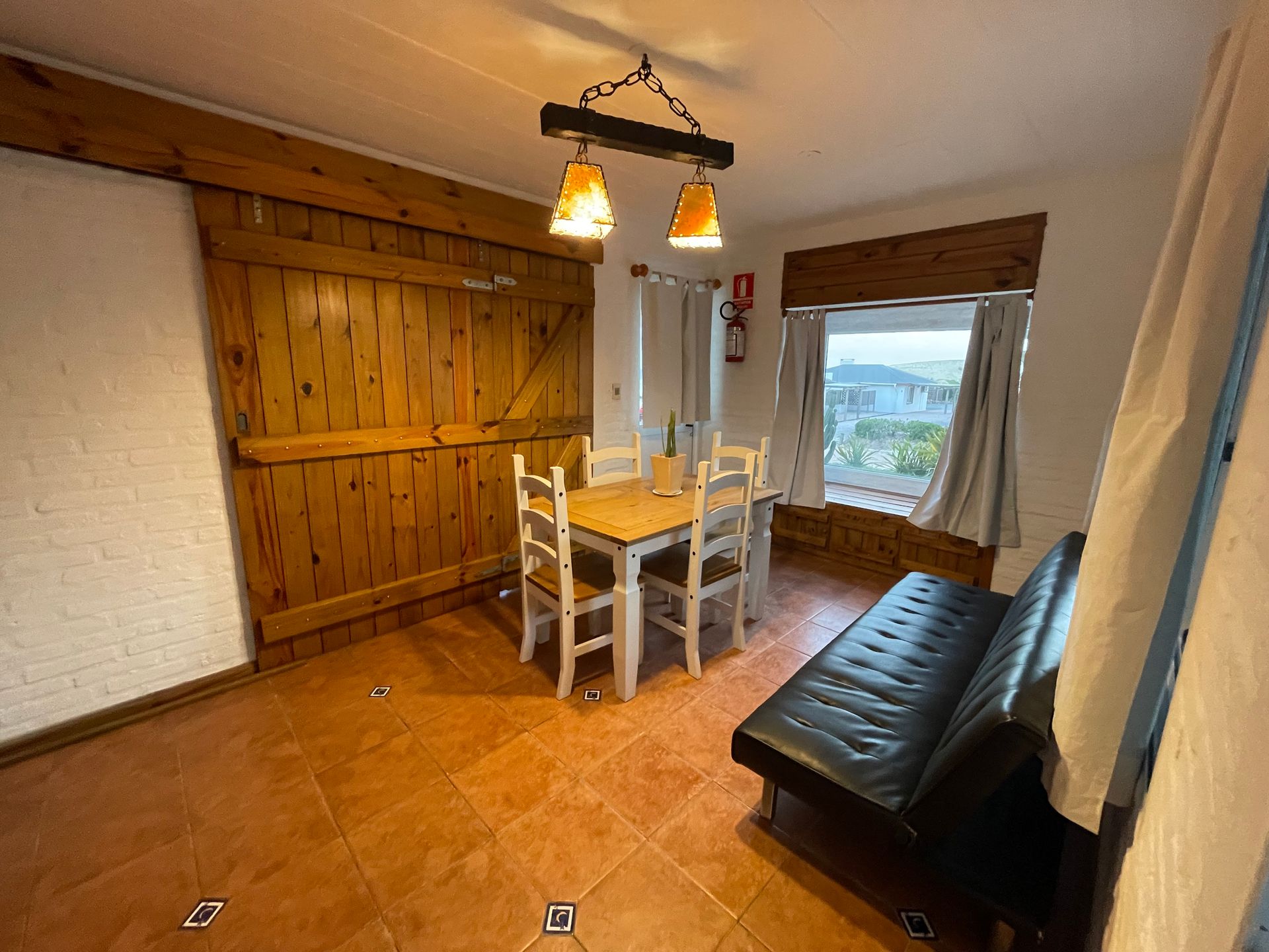 A living room with a table and chairs and a couch.