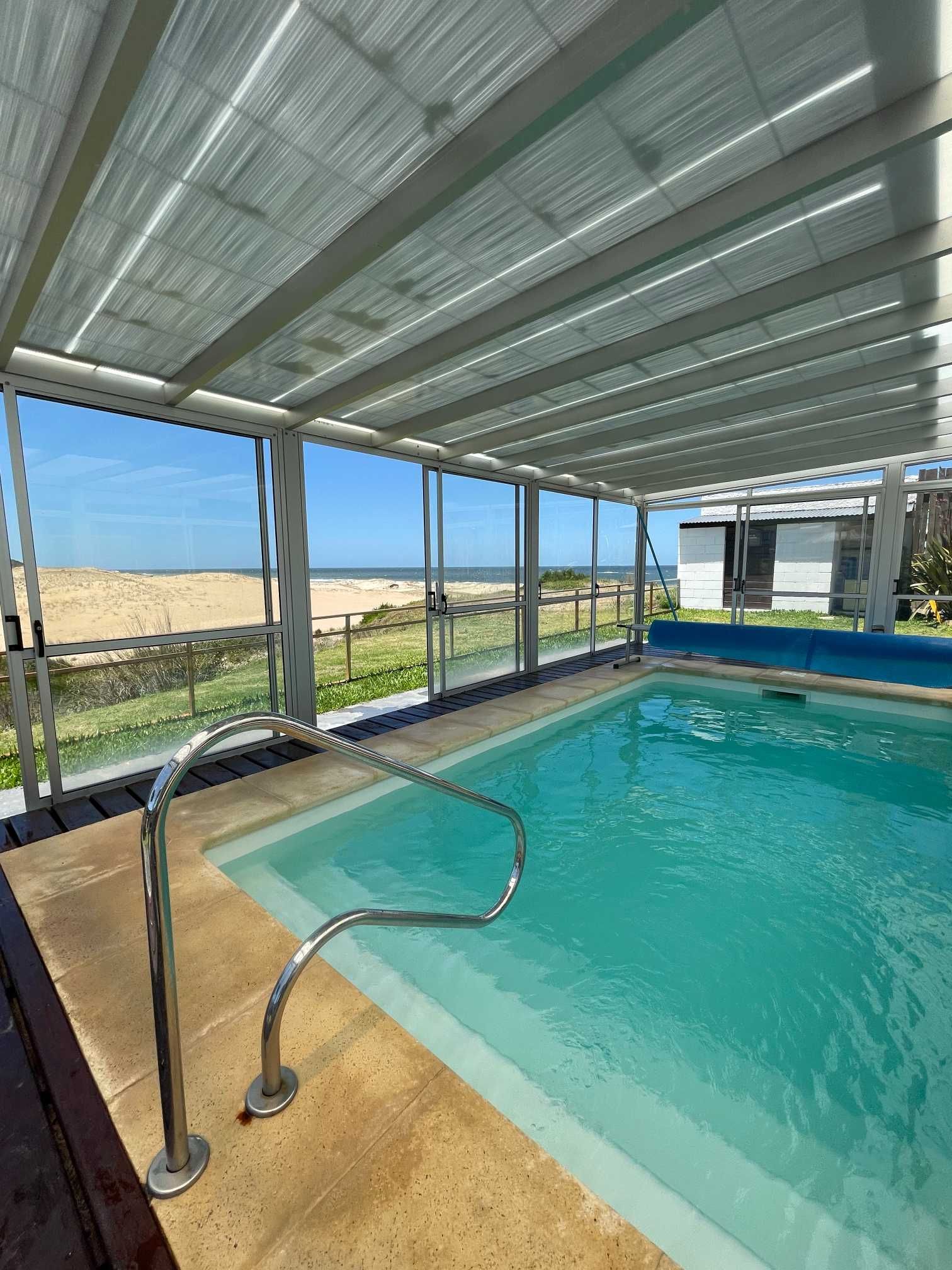 A large indoor swimming pool with a view of the ocean.