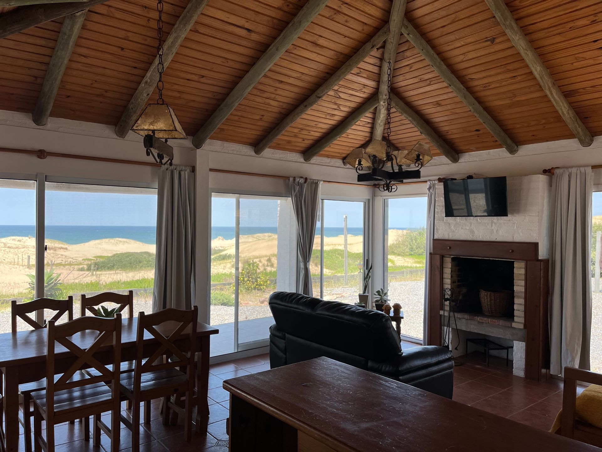 A living room with a dining table and chairs and a fireplace