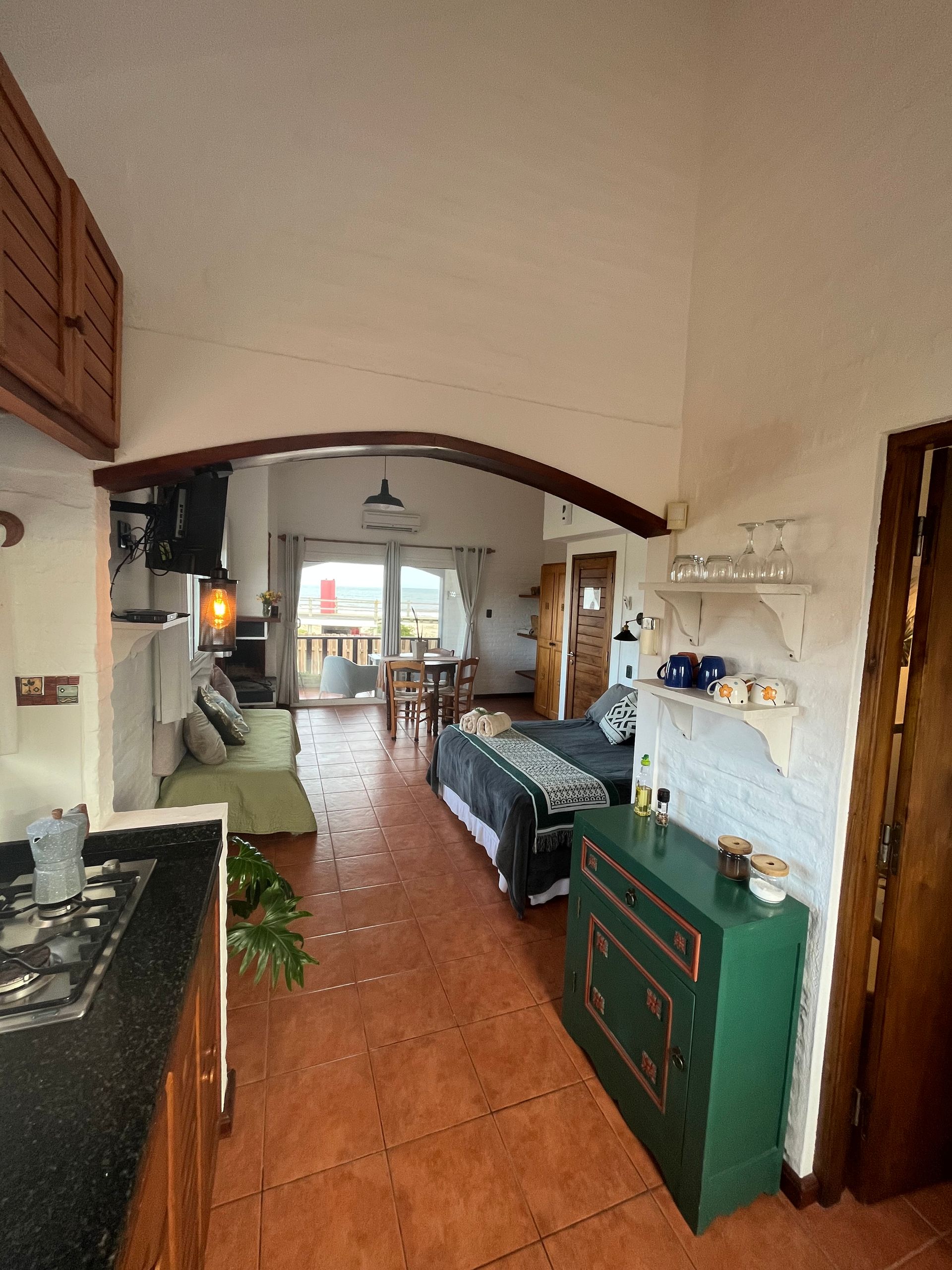 A kitchen with a stove top oven and a green cabinet