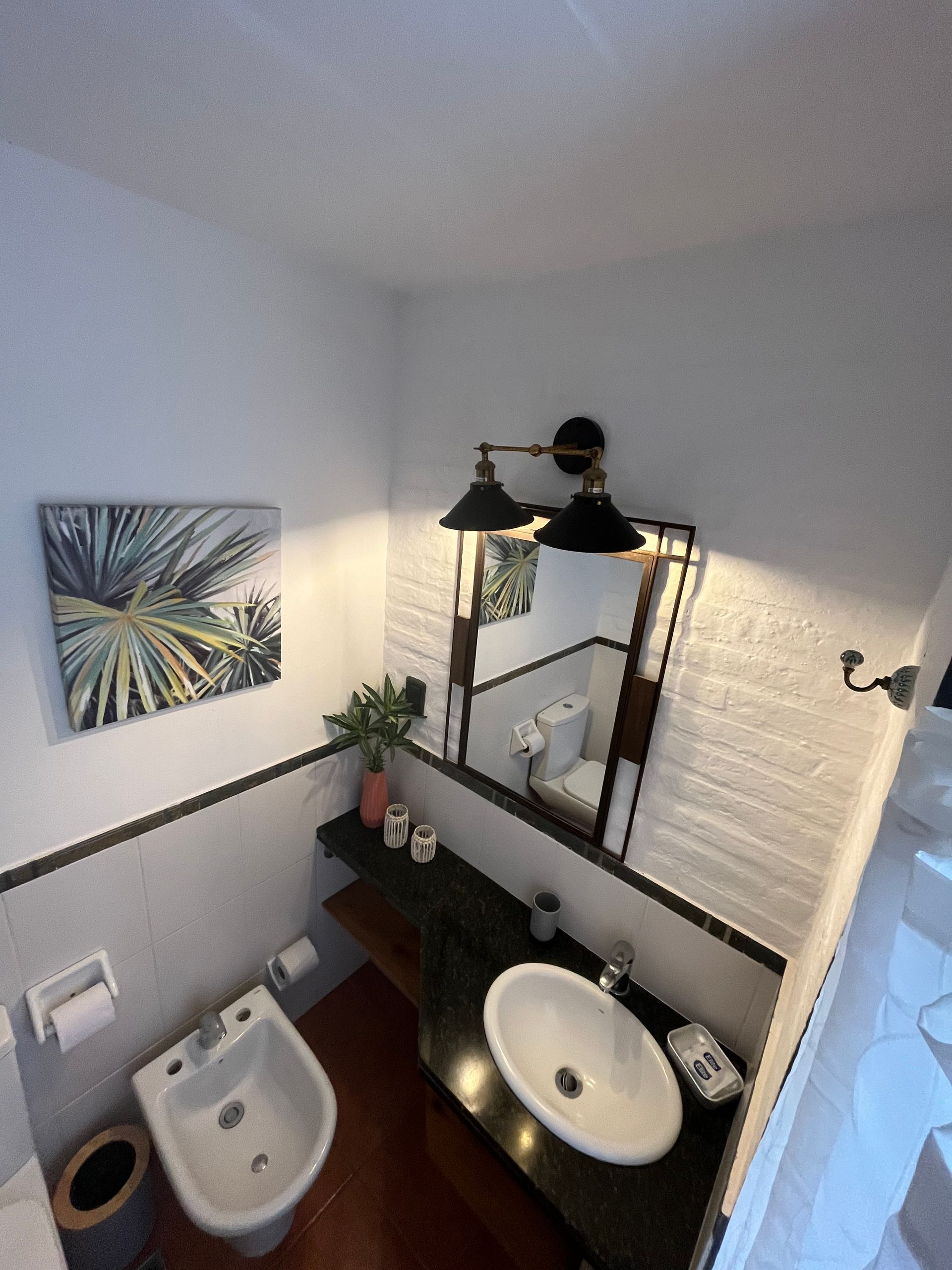 A bathroom with a sink a toilet and a mirror