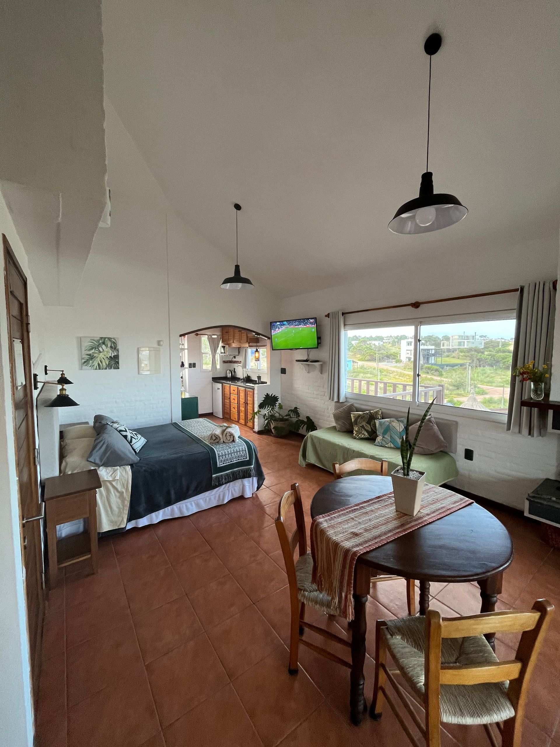 A living room with a table and chairs and a bed