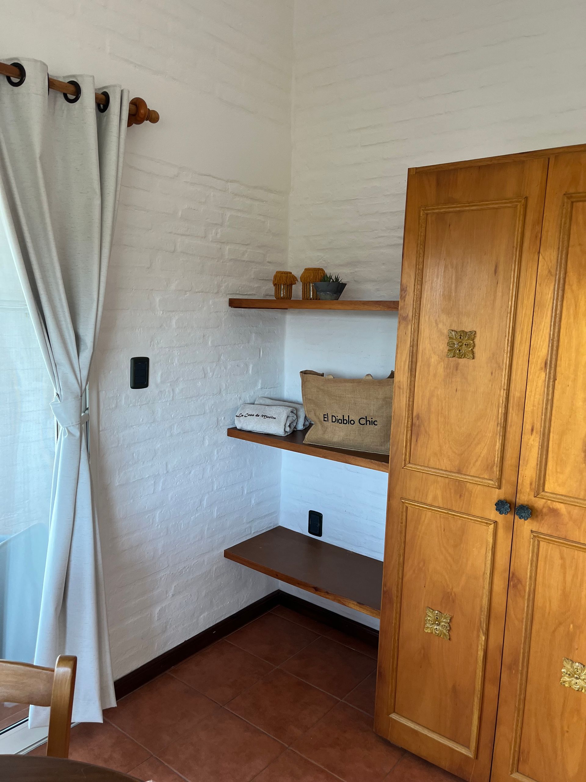 A room with a wooden door and shelves on the wall.