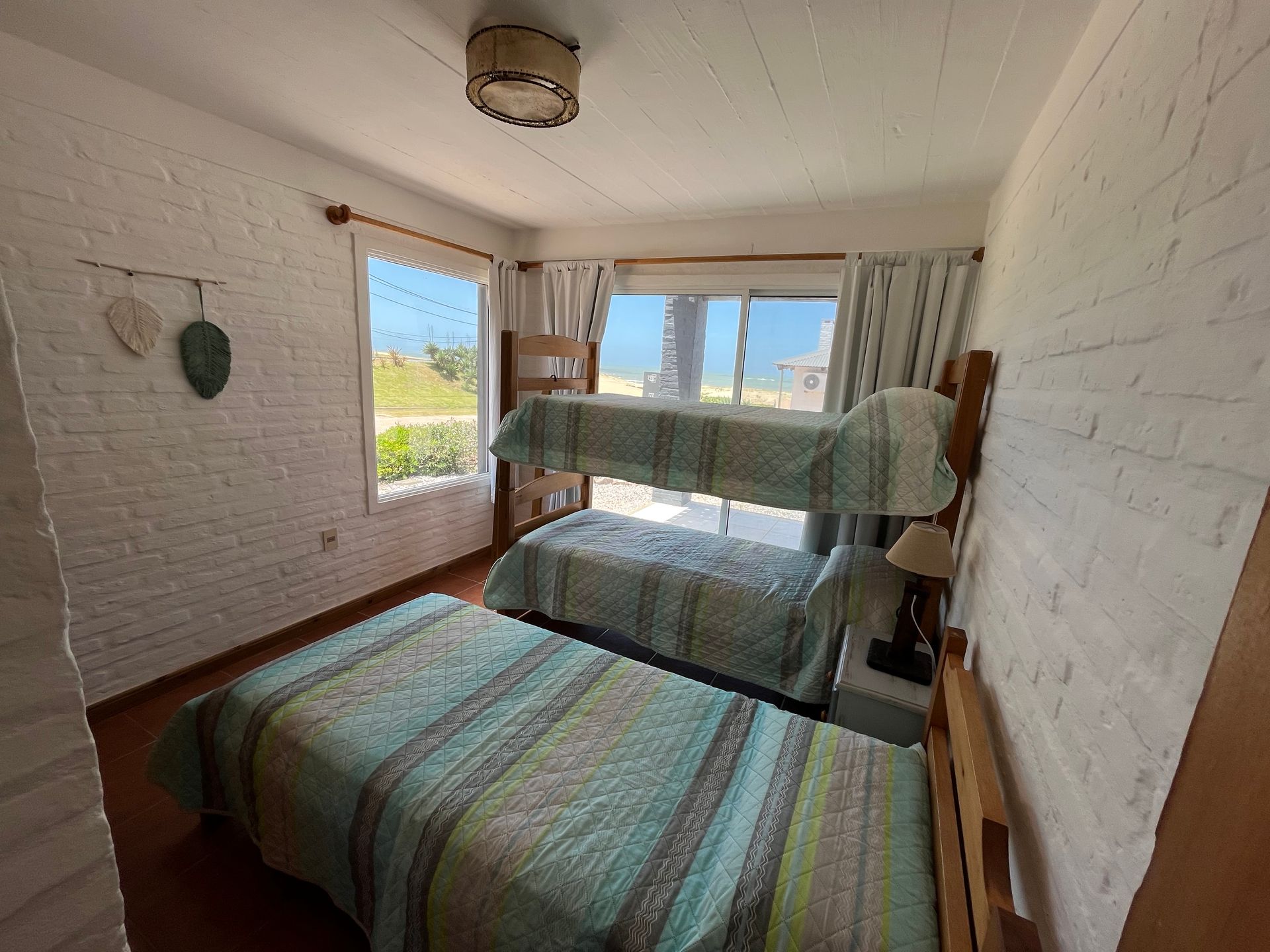 A bedroom with two beds and a bunk bed.