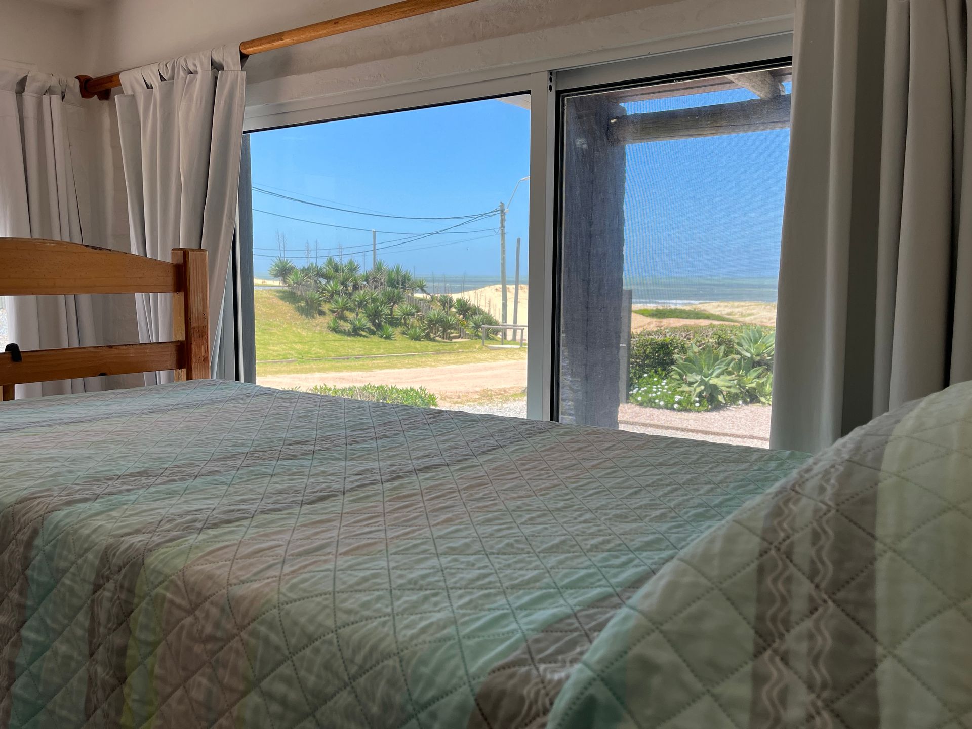 A bedroom with a bed and a window with a view of the ocean.