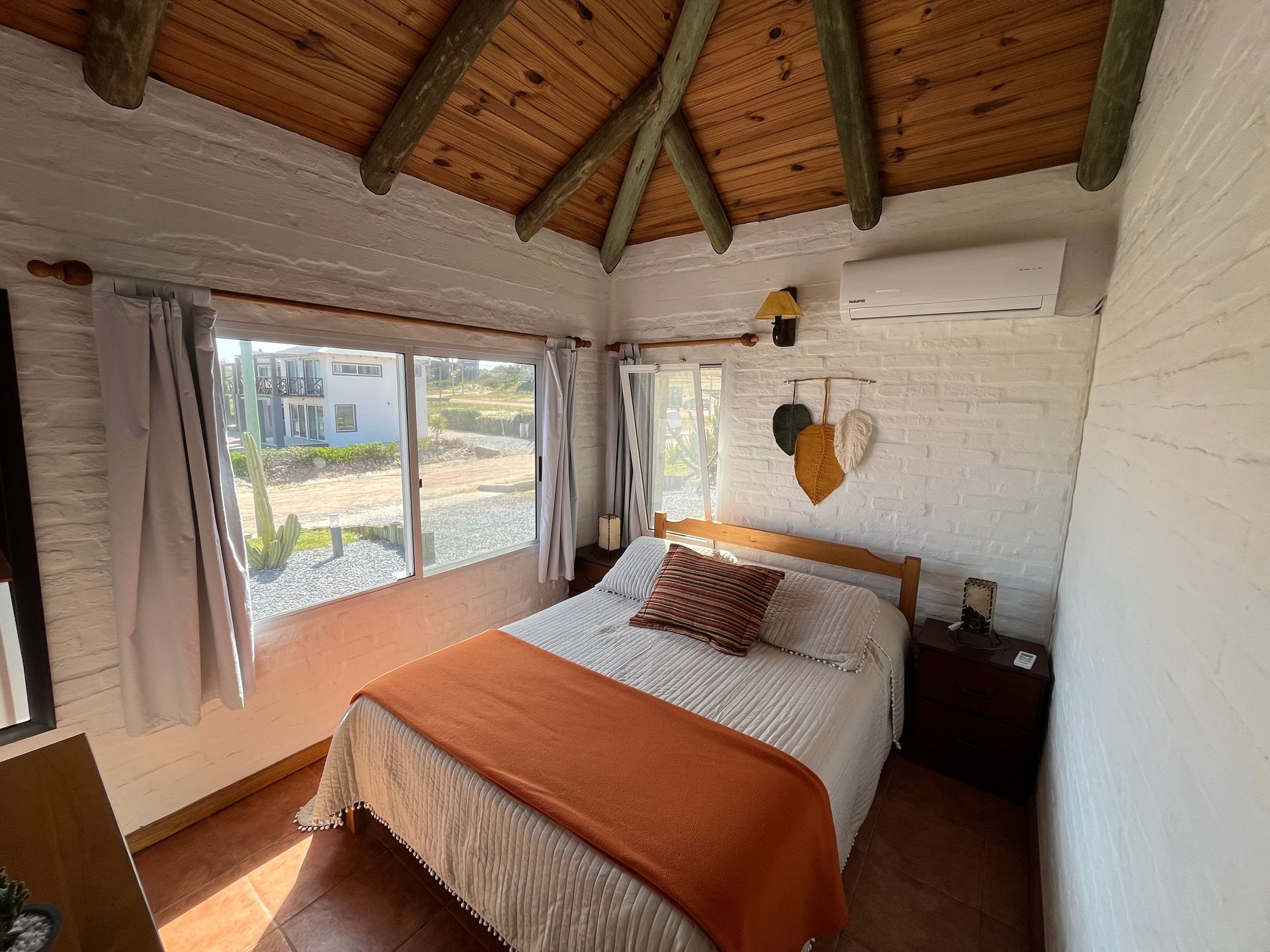 There is a bed in the middle of the room with a wooden ceiling.