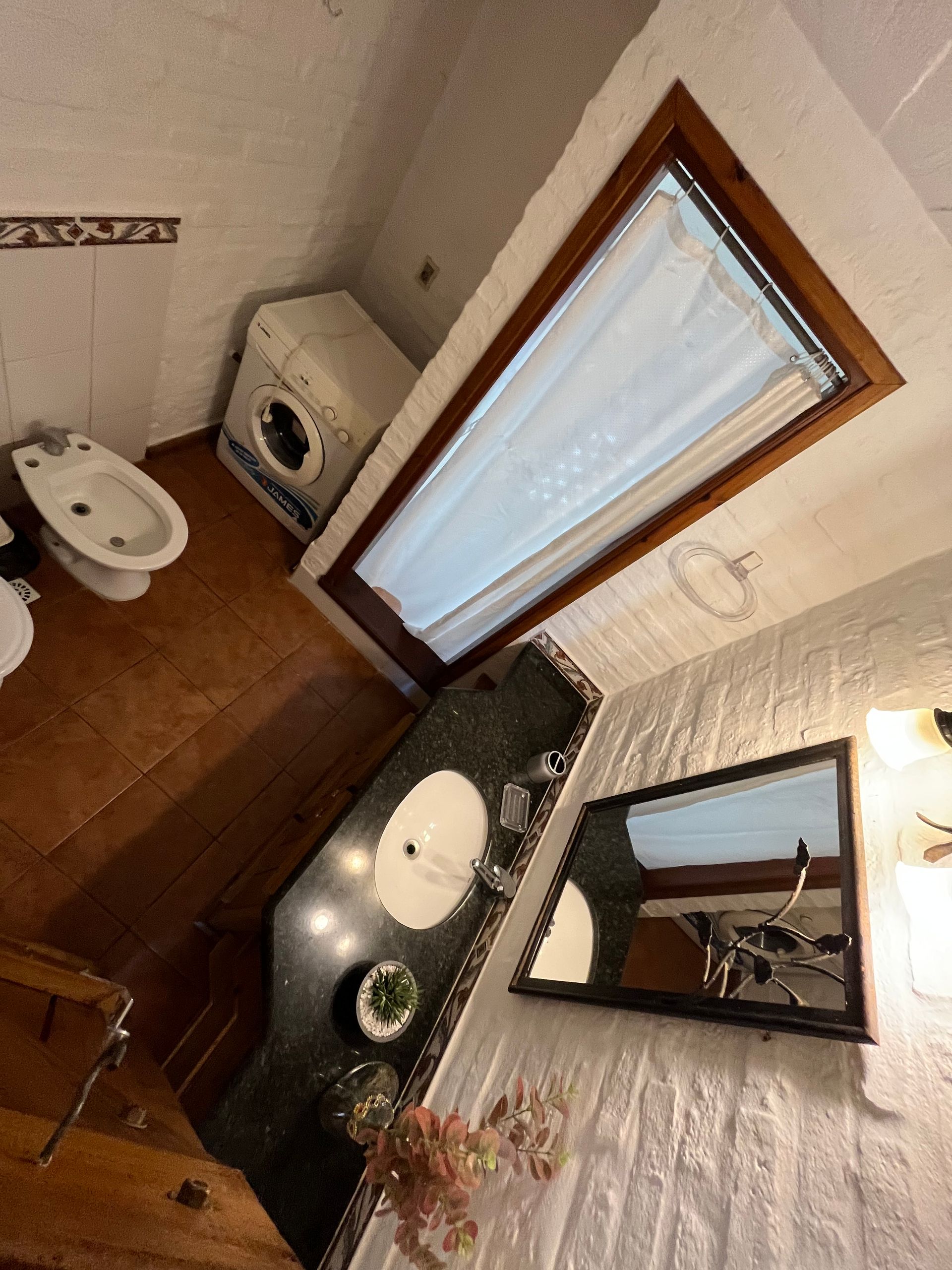 A bathroom with a toilet a sink and a mirror