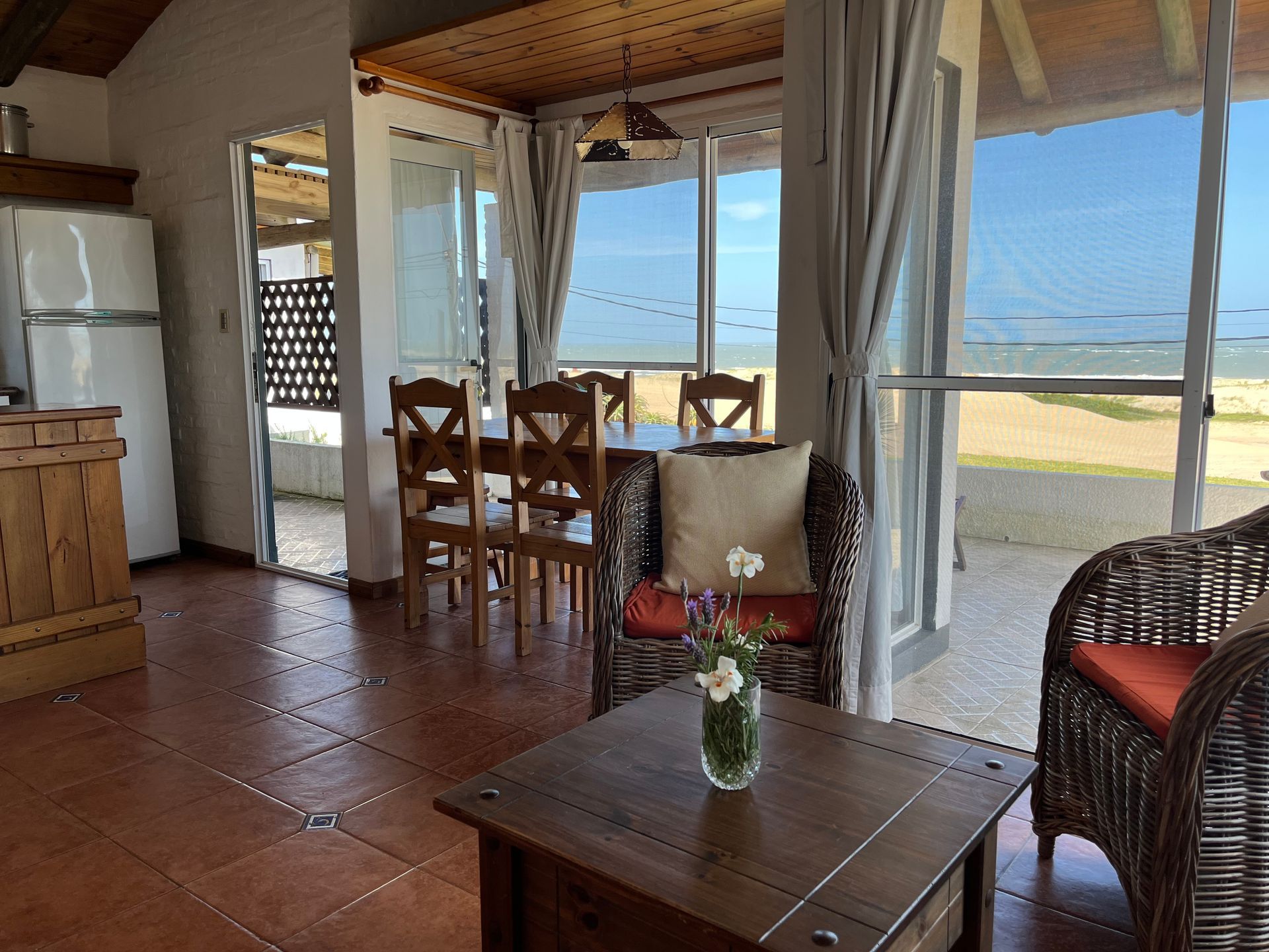 A living room with a table and chairs and a view of the ocean