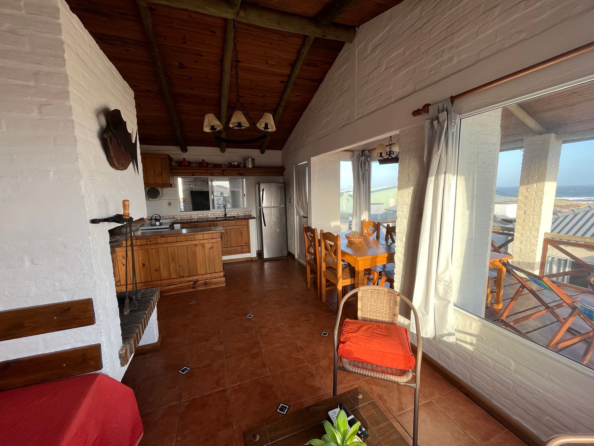 A living room with a table and chairs and a refrigerator