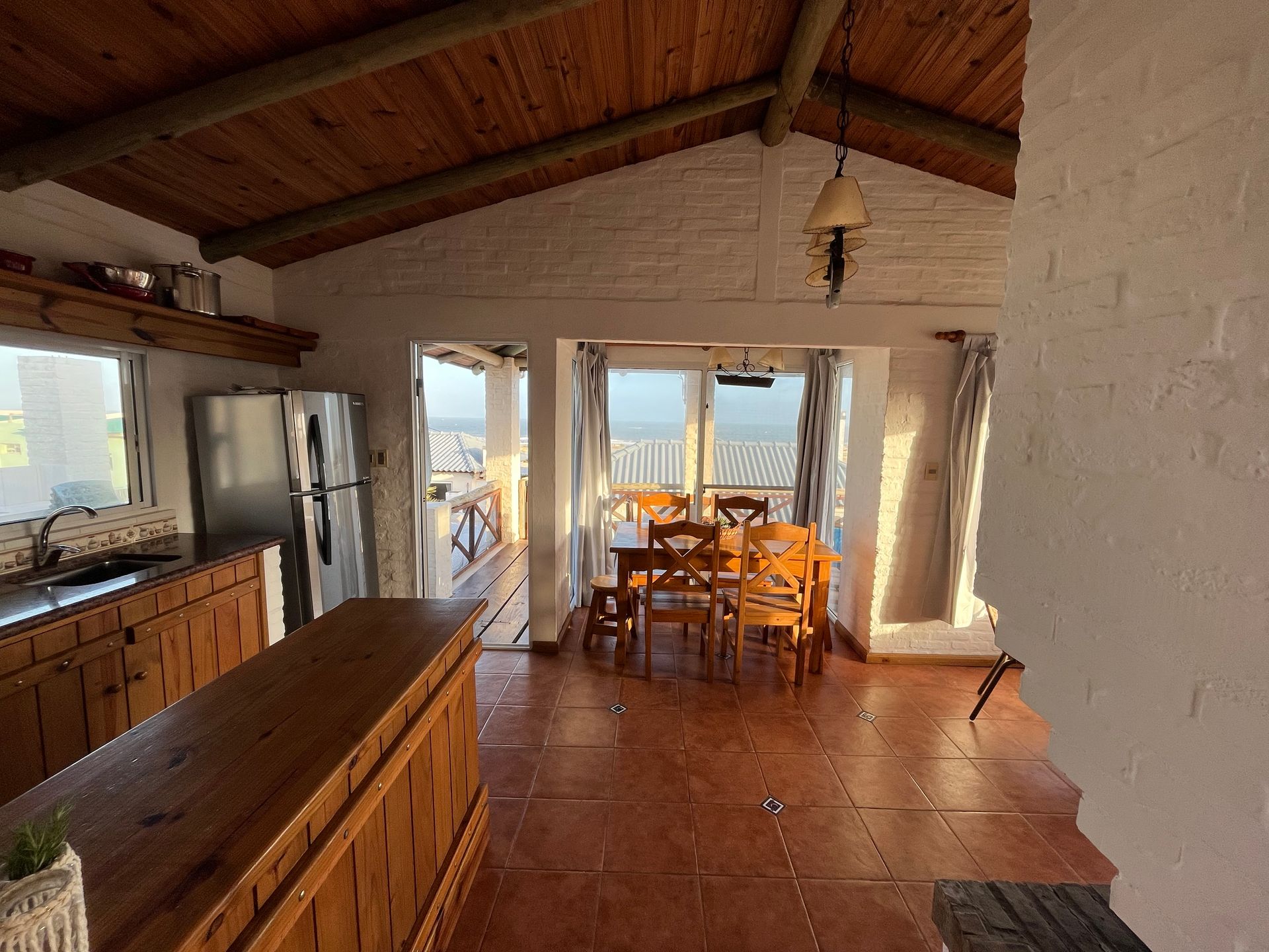 A kitchen and dining room in a house with a view of the ocean.
