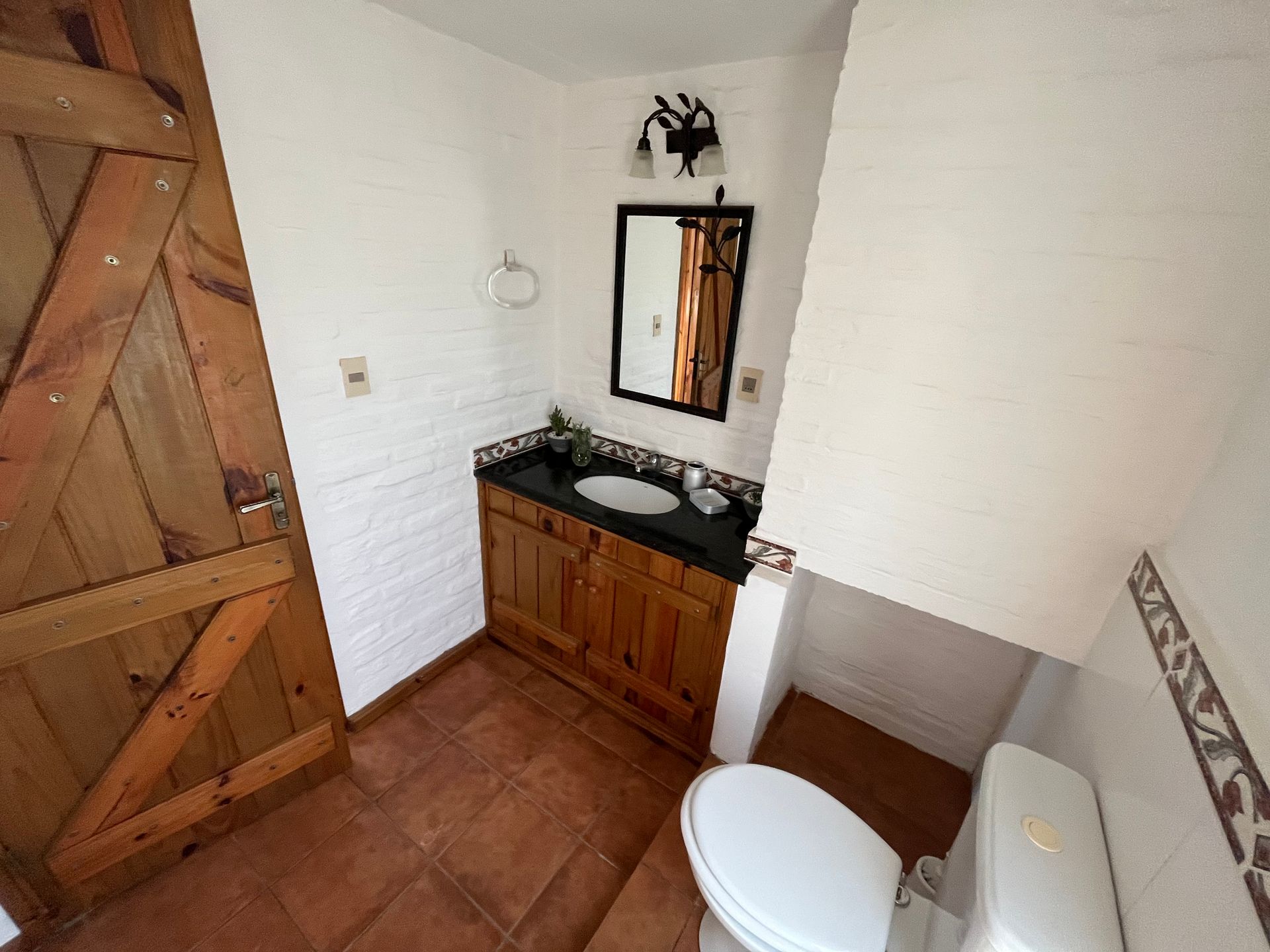 A bathroom with a toilet a sink and a mirror