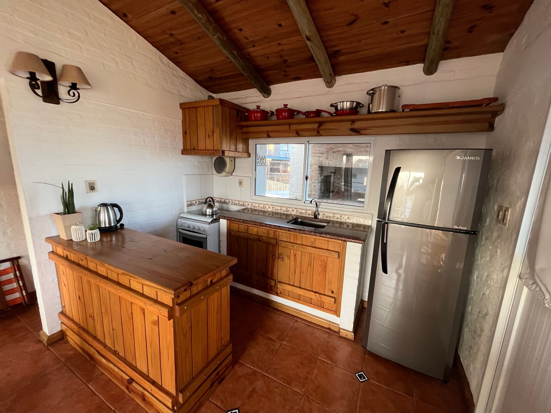 A kitchen with wooden cabinets and a stainless steel refrigerator