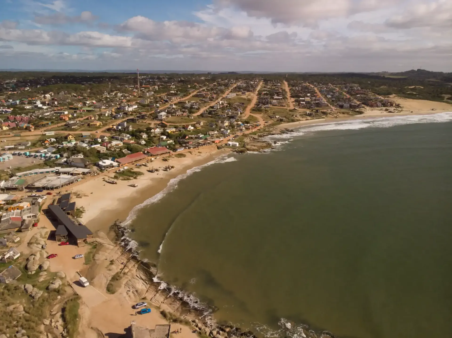 An aerial view of a beach with a city in the background.