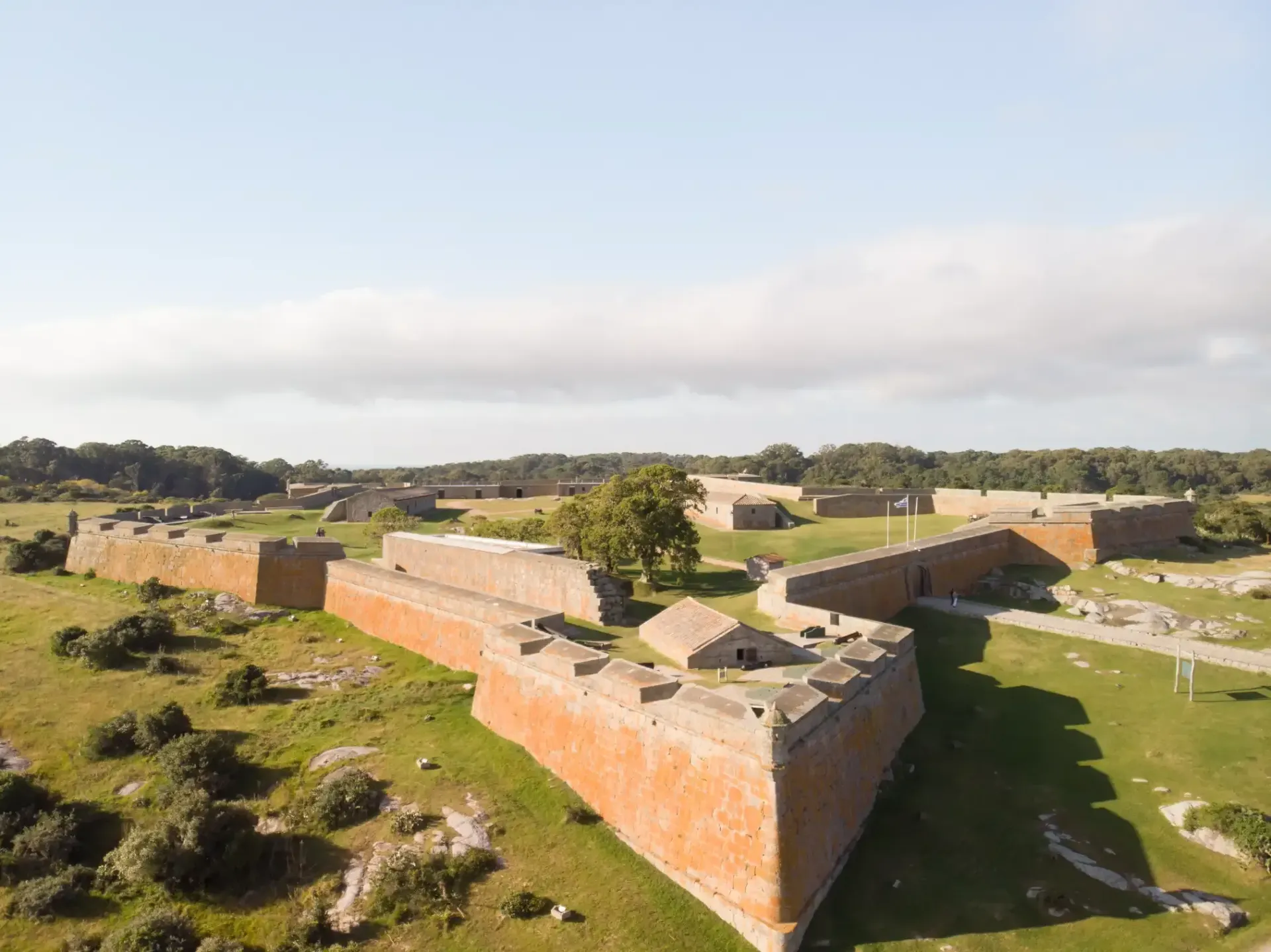 An aerial view of a large brick building in the middle of a field.