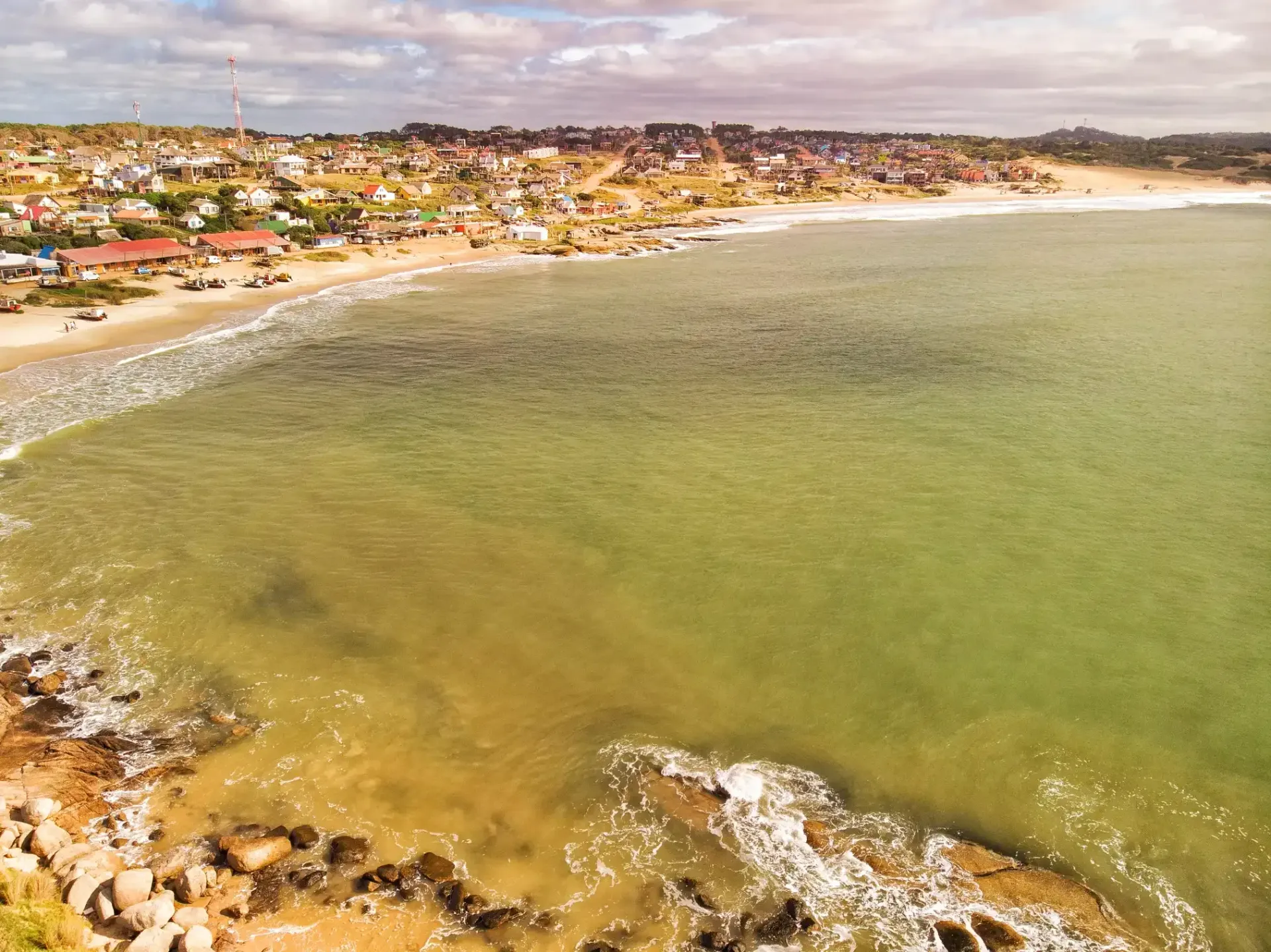 An aerial view of a beach with a city in the background.