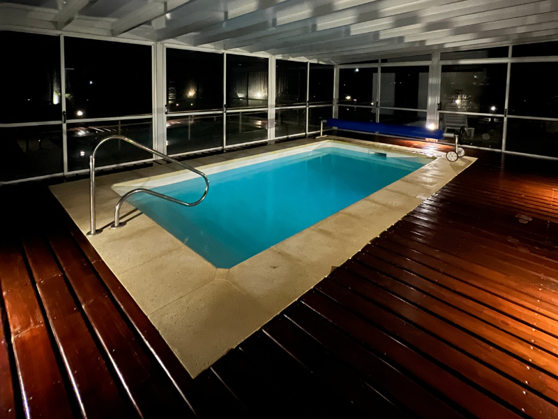 A large indoor swimming pool with a wooden deck